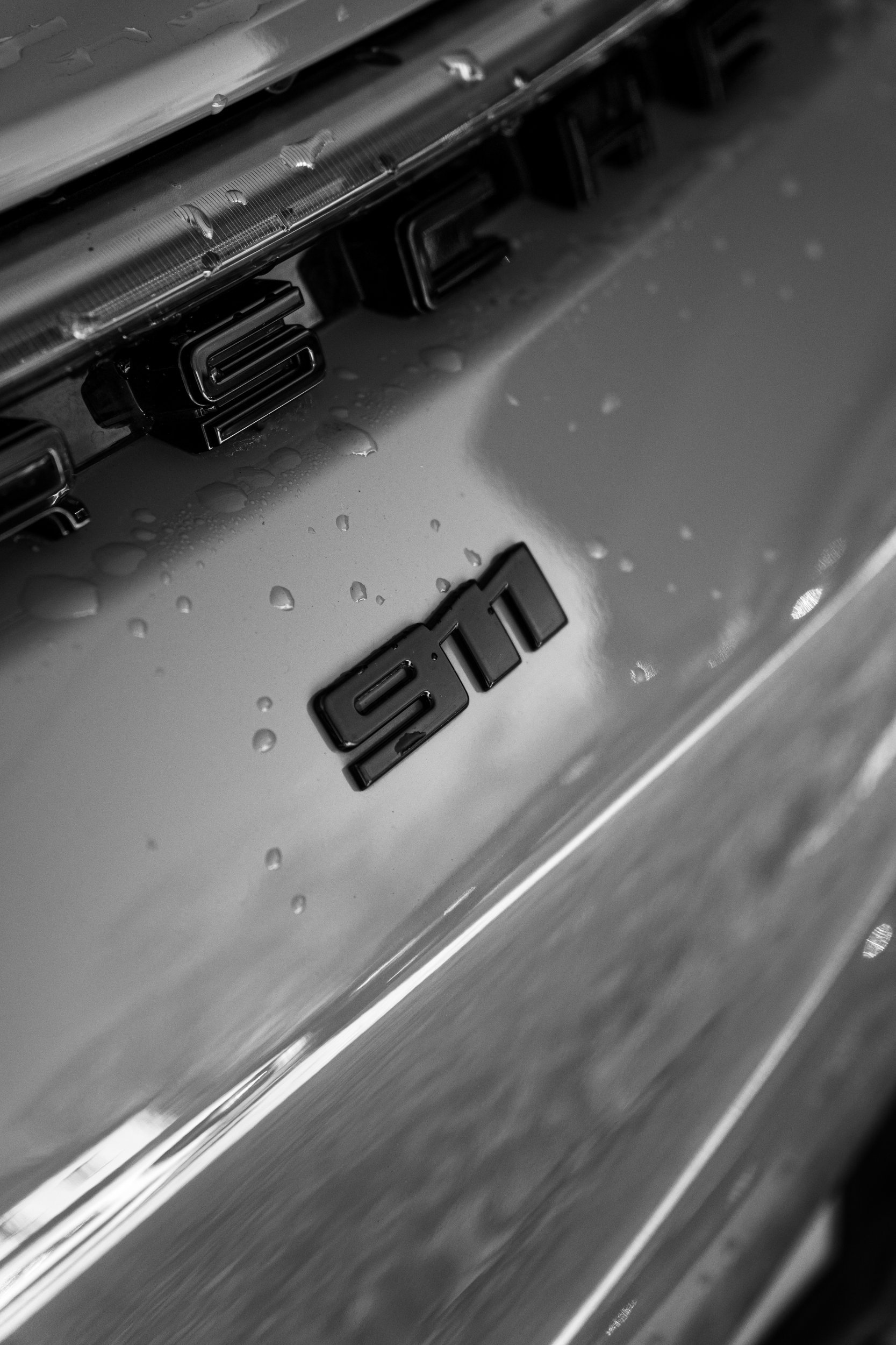 911-Schriftzug am Porsche in Schwarzweiß – Detailaufnahme