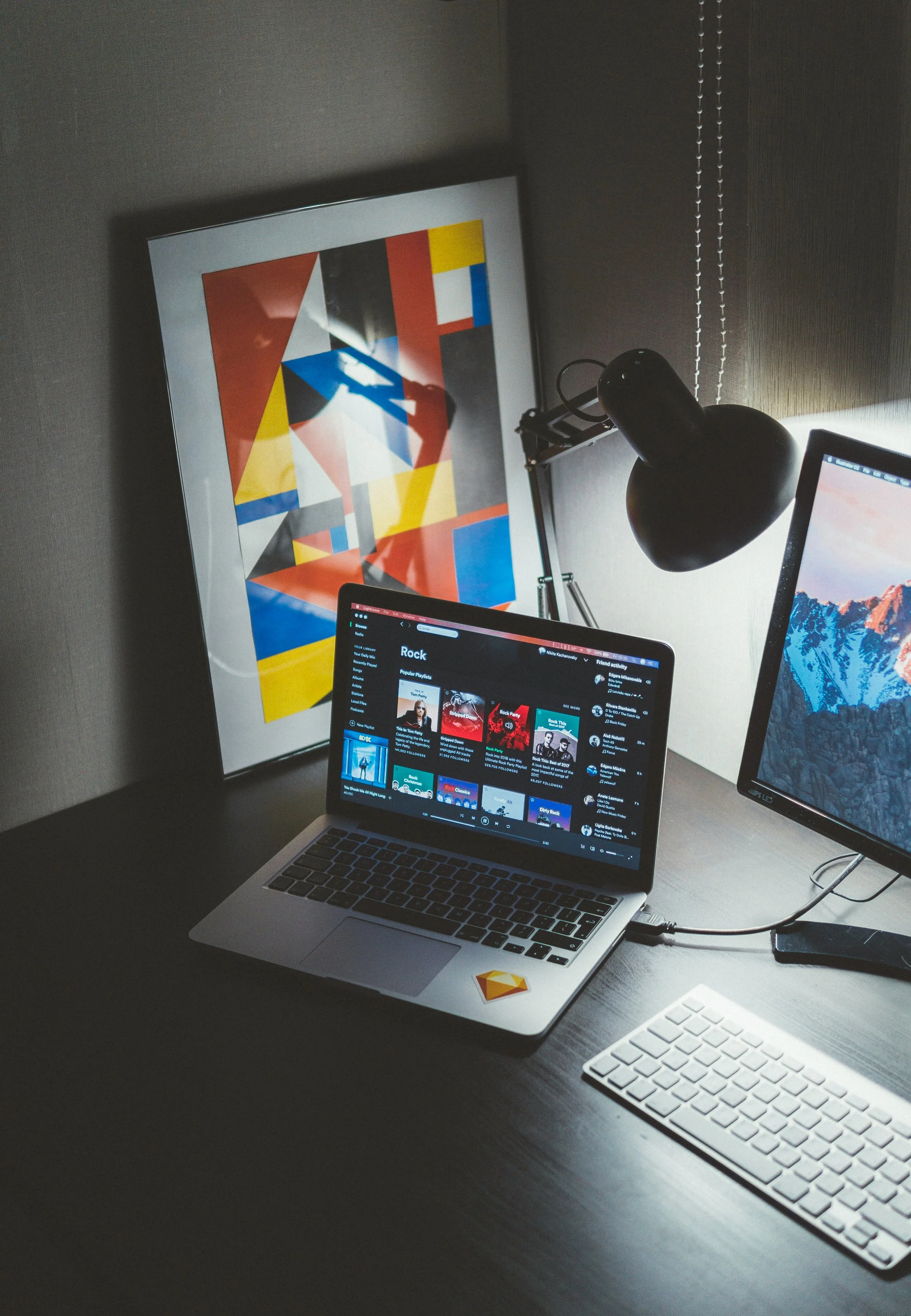 A desktop workspace with a laptop, monitor and design details.