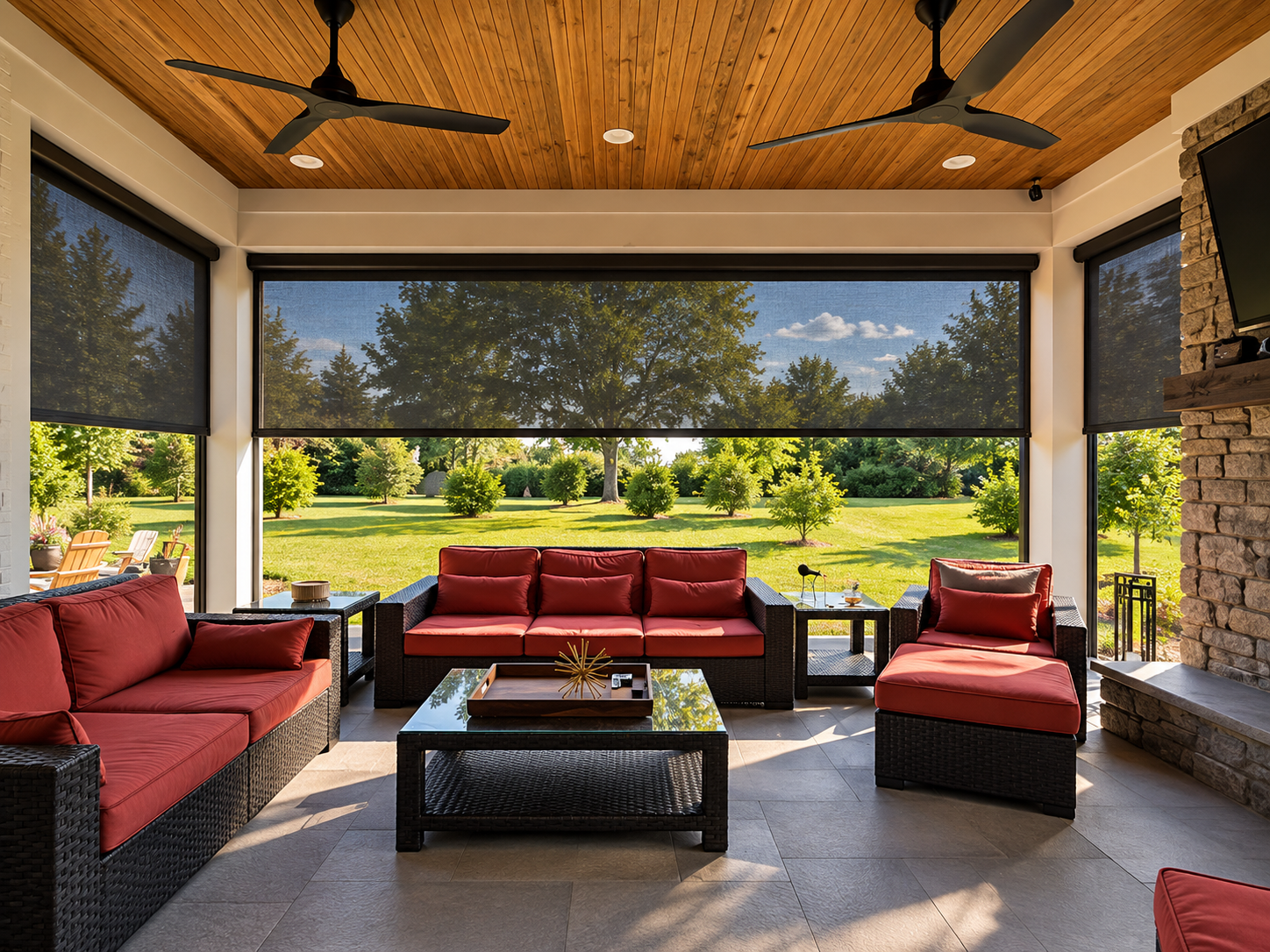 A sunroom with wicker furniture and red cushions.