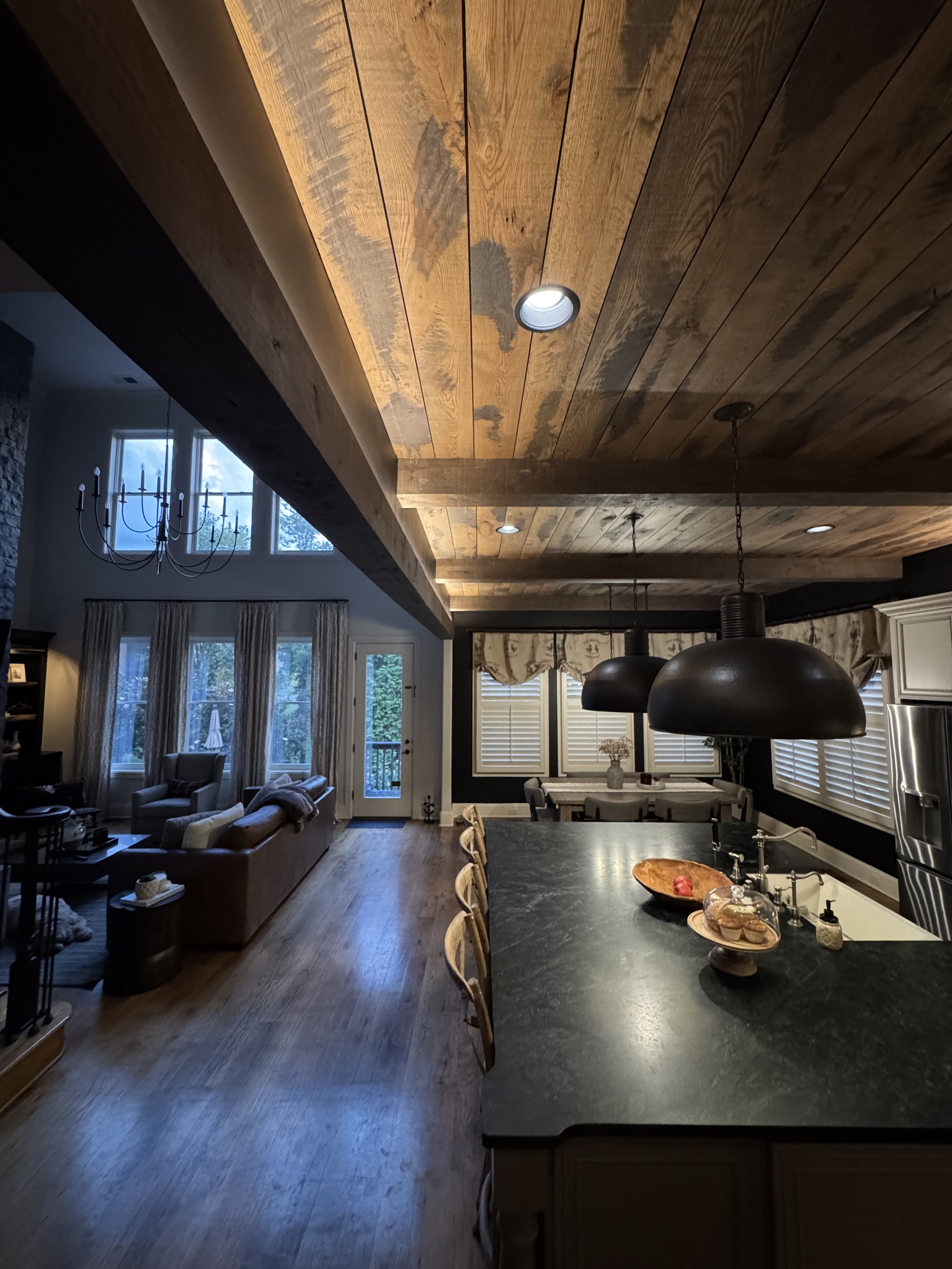 Open-concept kitchen and living room with recessed and pendant lighting installed by Vigilant Voltage Electric