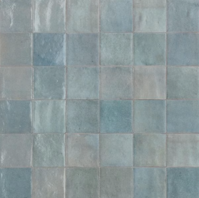 Close-up of a wall with square blue-green ceramic tiles.