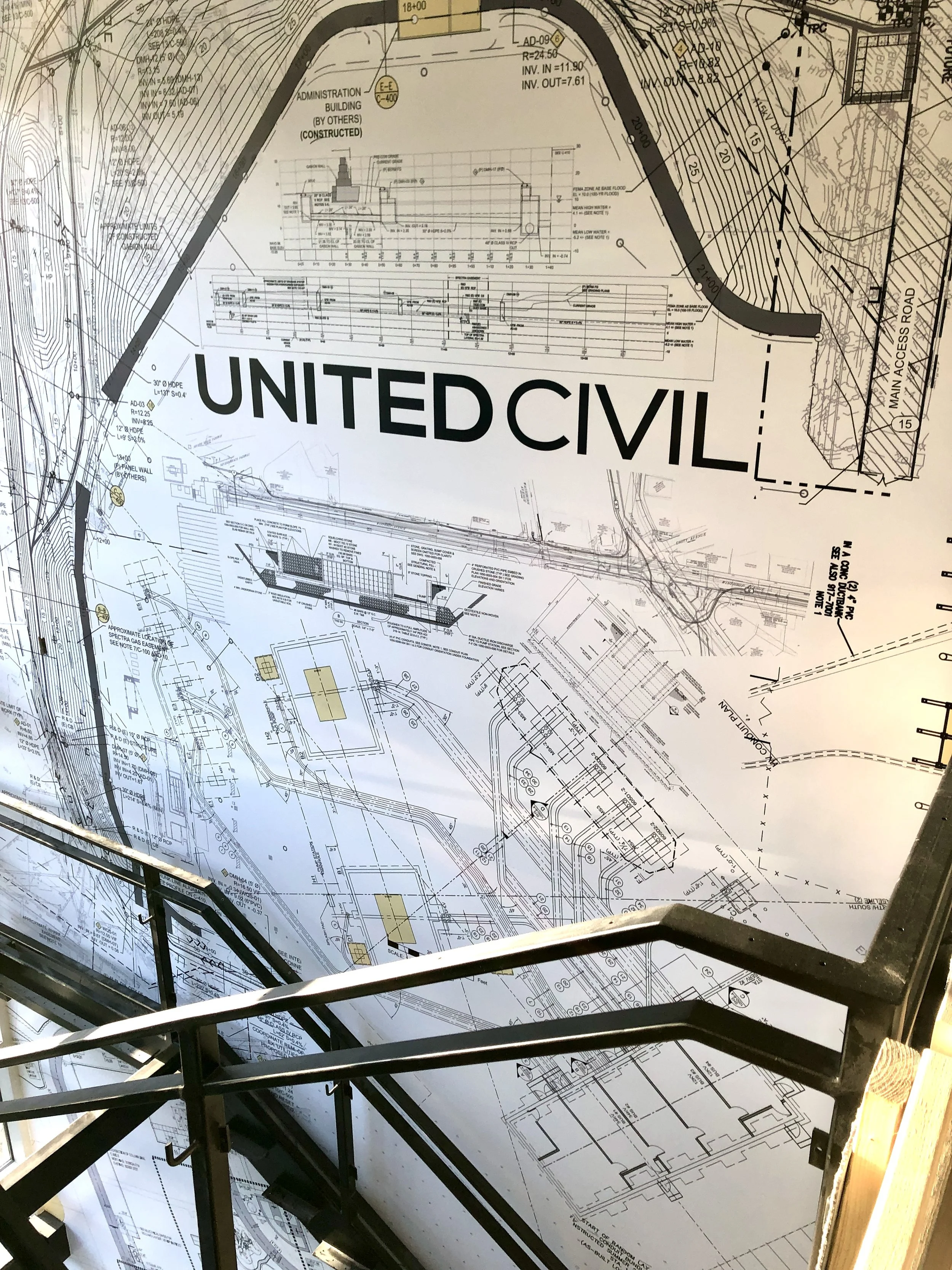 Detailed civil engineering construction plans showing a site layout, topographic contours, utility lines, road access, building sections, and a large “UNITED CIVIL” label.