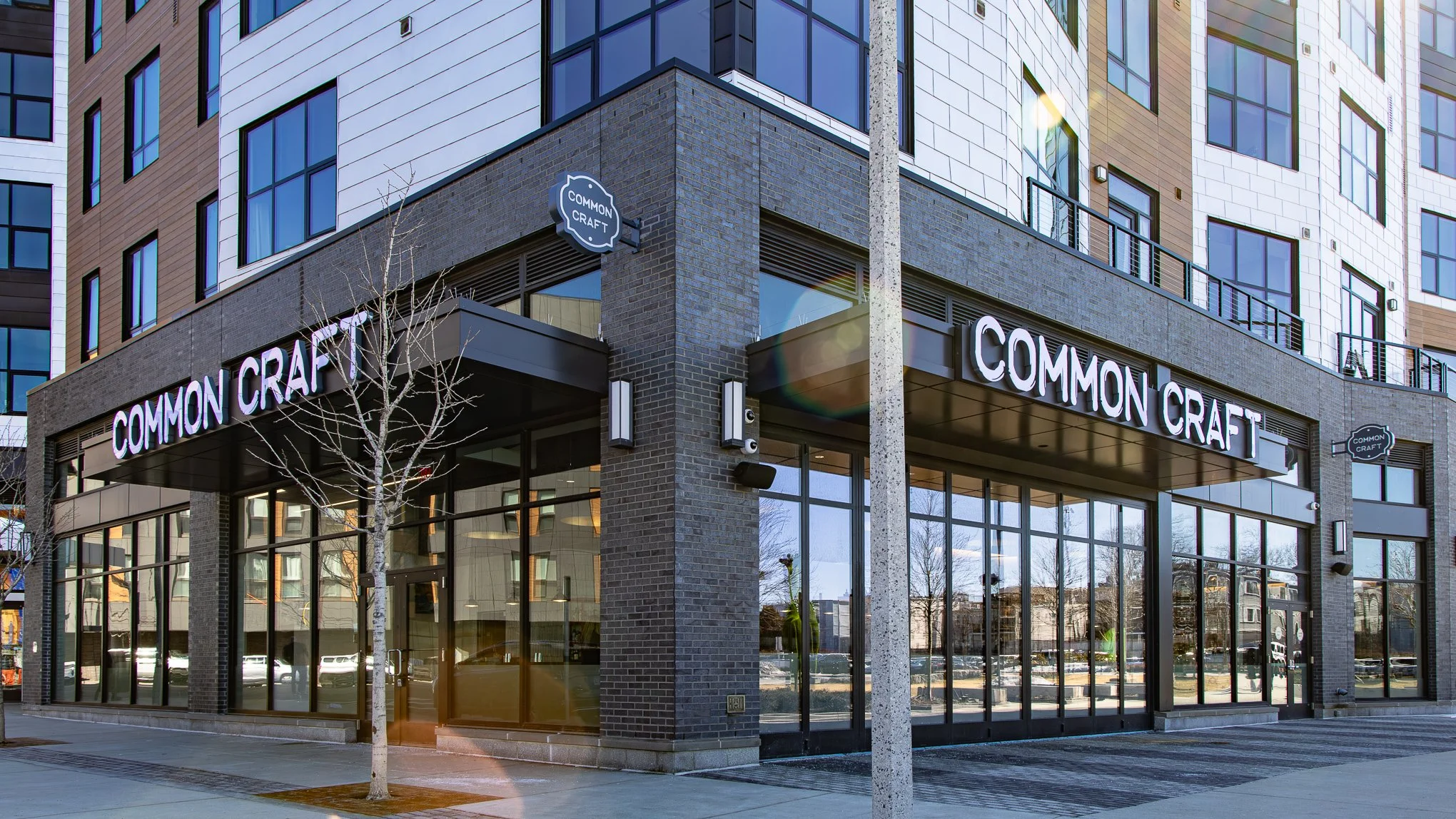 Exterior of the Common Craft restaurant in a modern brick-and-glass apartment building