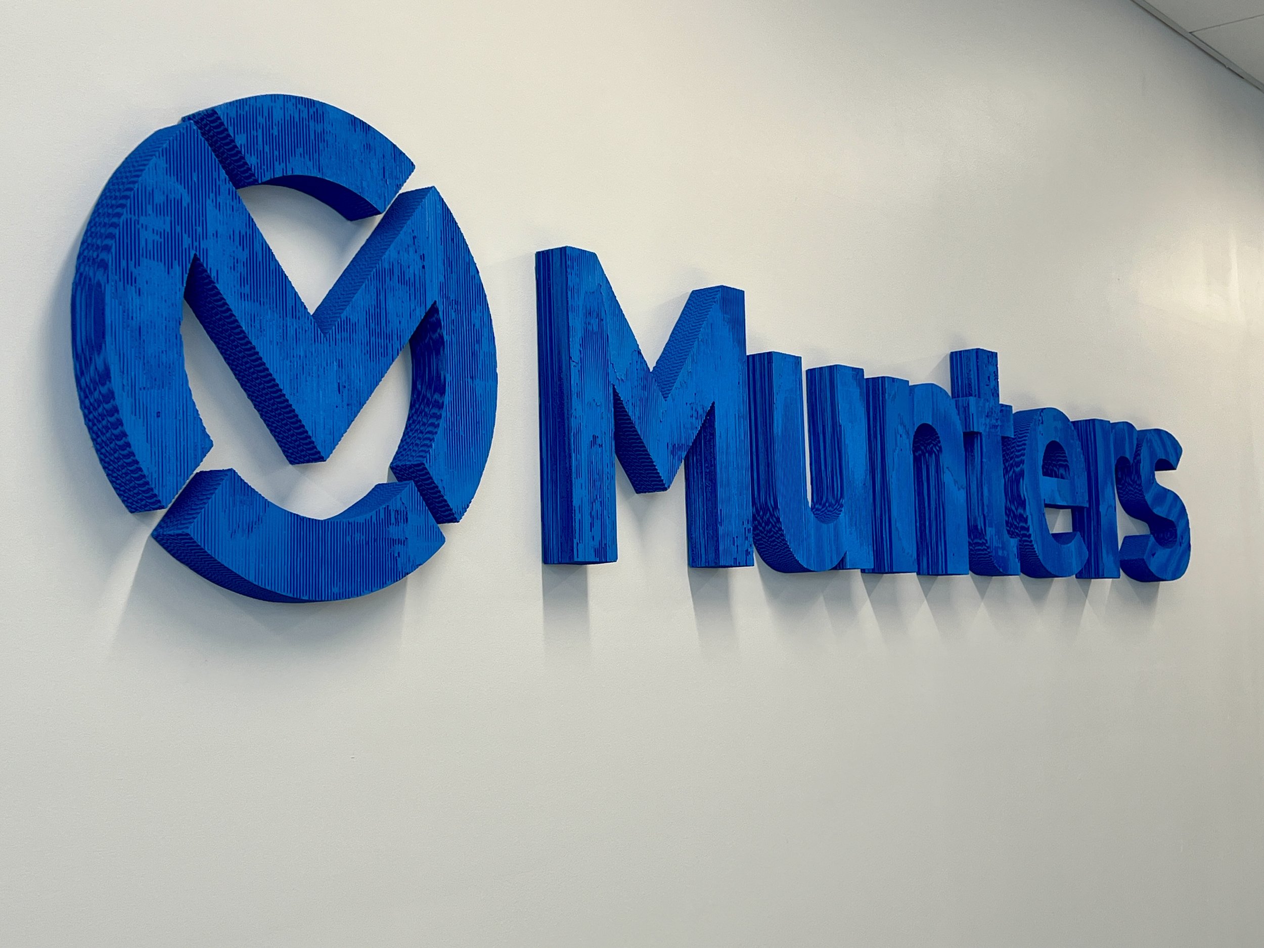 Blue 3D wall sign featuring a stylized logo and the word “Makers.”