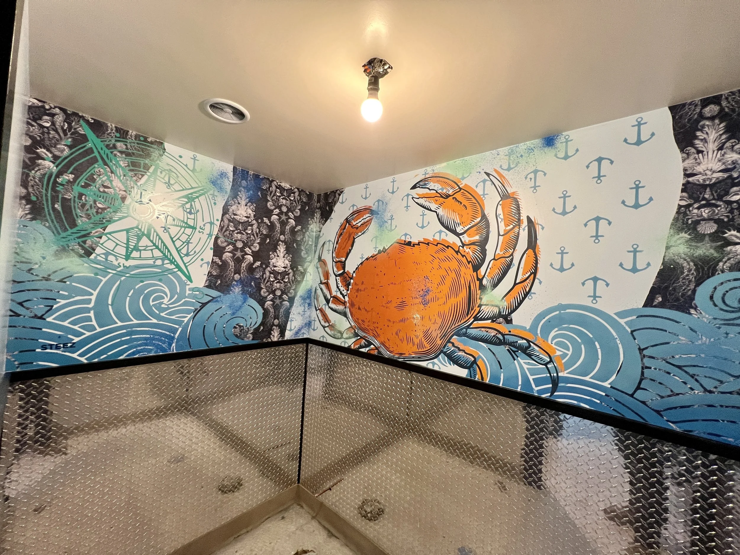 Colorful nautical mural featuring an orange octopus, blue waves, anchors, and a ship’s wheel above diamond-plate metal panels