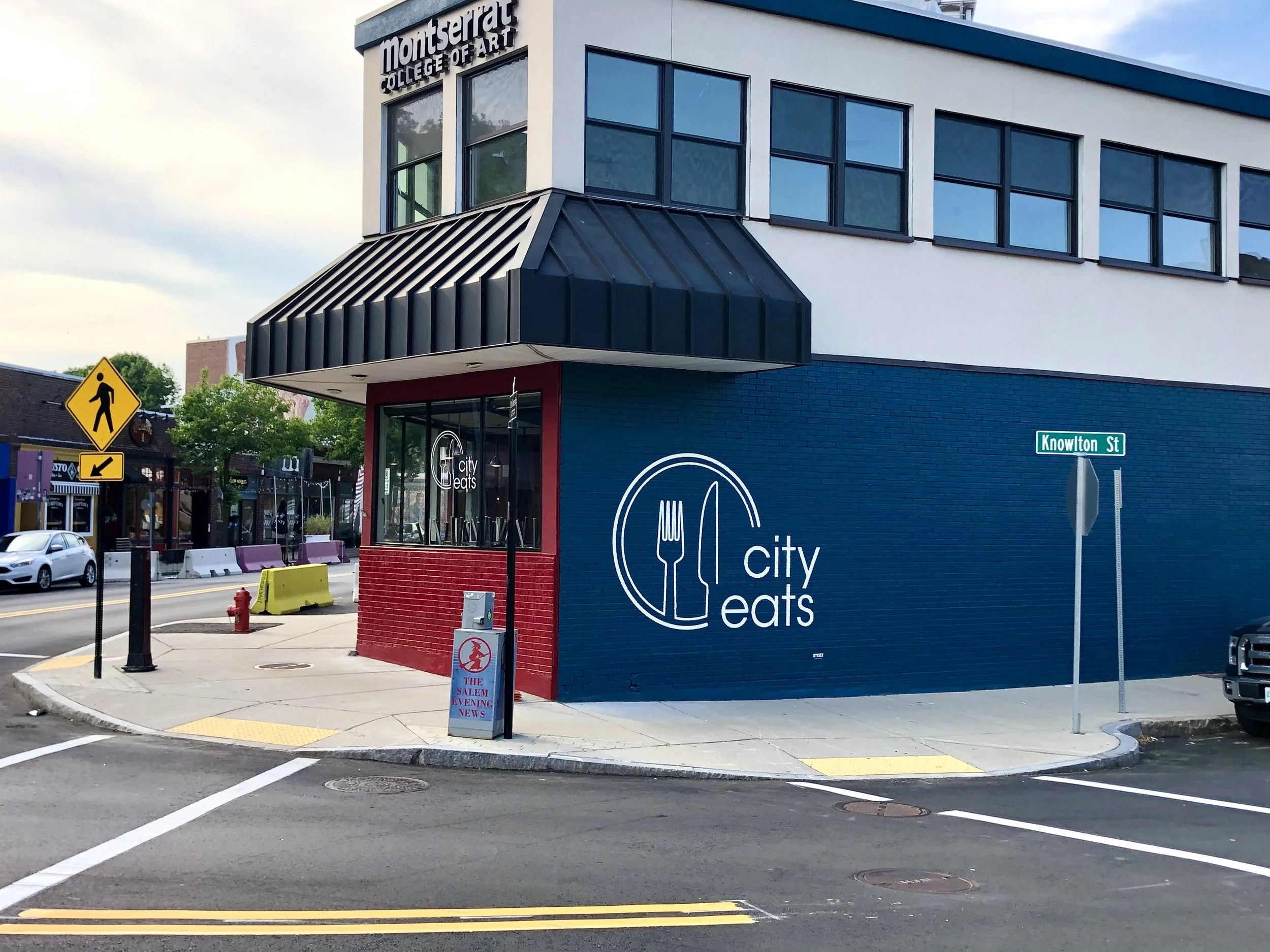 City Eats restaurant at the corner of Knowlton Street, with Montserrat College of Art signage above