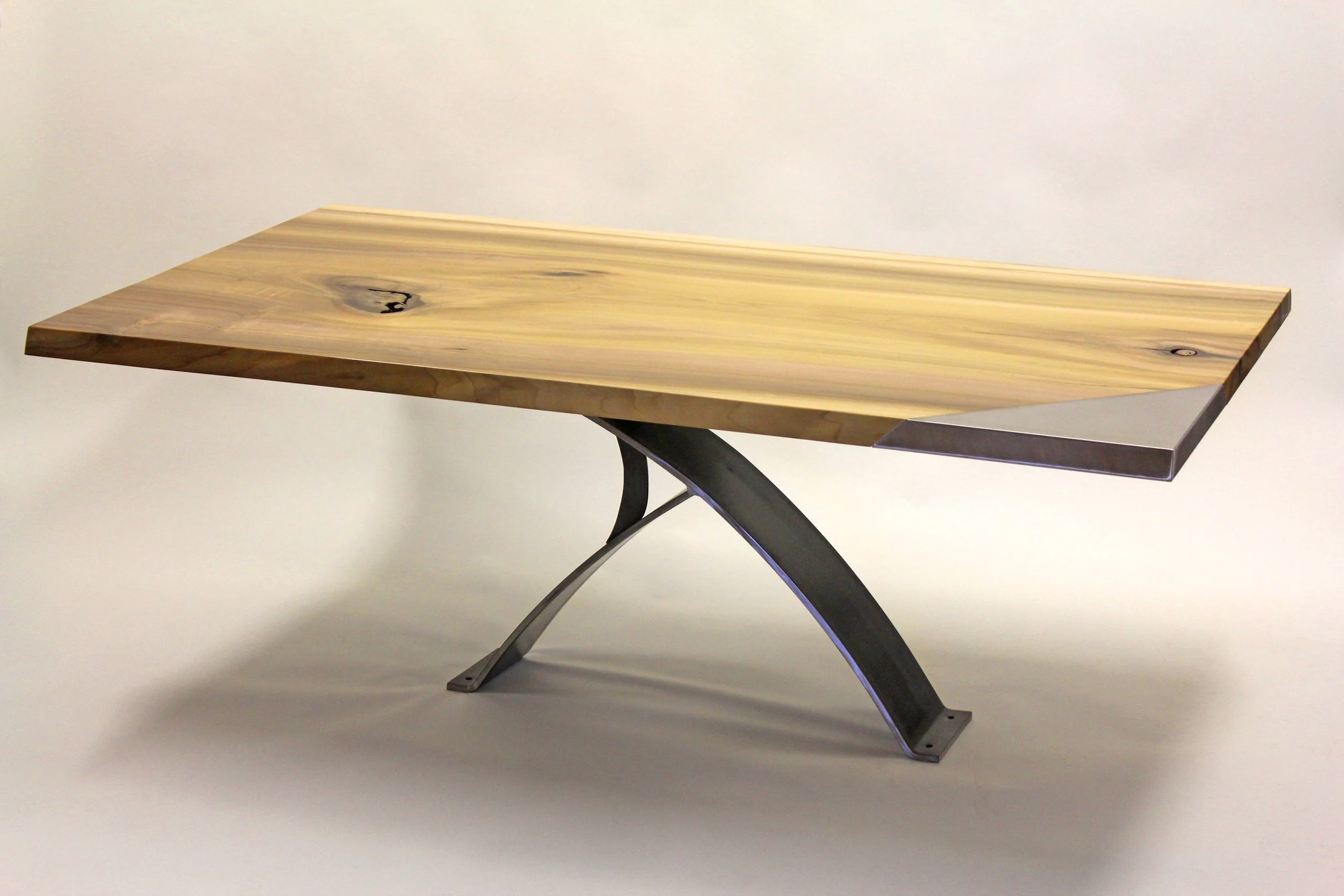 Live-edge wood dining table with a sculptural black metal base