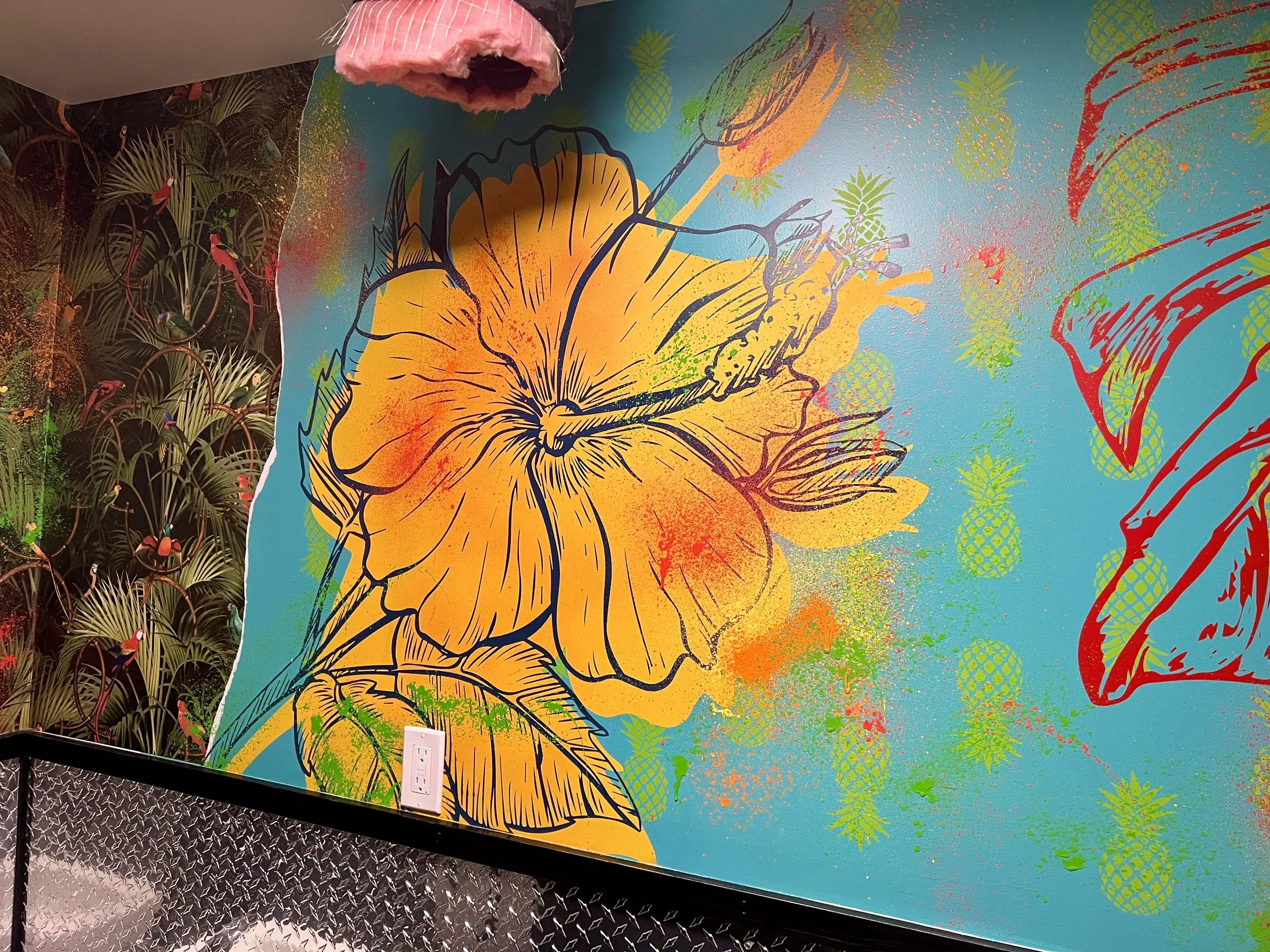 Colorful tropical mural featuring a large orange hibiscus, hummingbird, pineapples, and exotic birds.