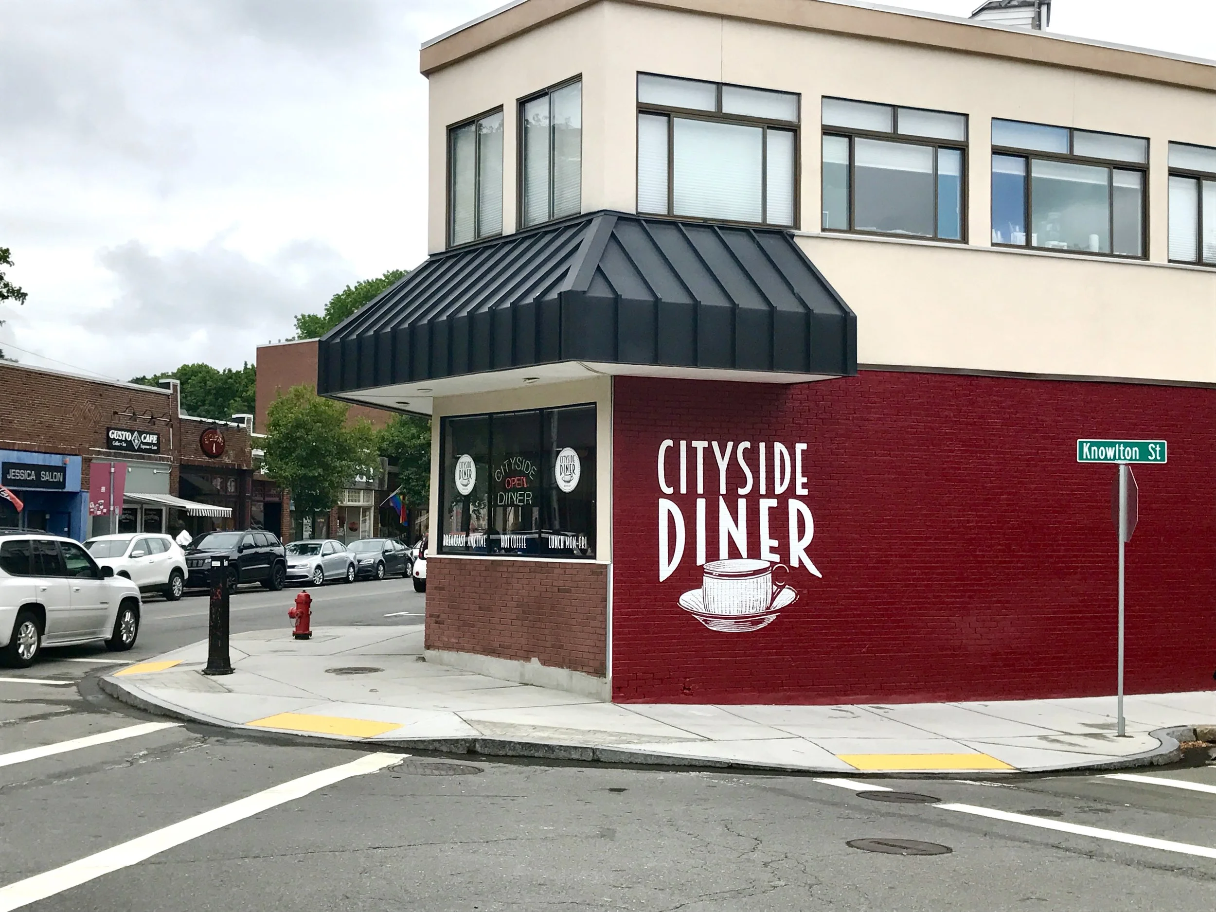 Cityside Diner restaurant at the corner of Knowlton Street, with a red brick exterior, street sign, parked cars, and neighboring shops.
