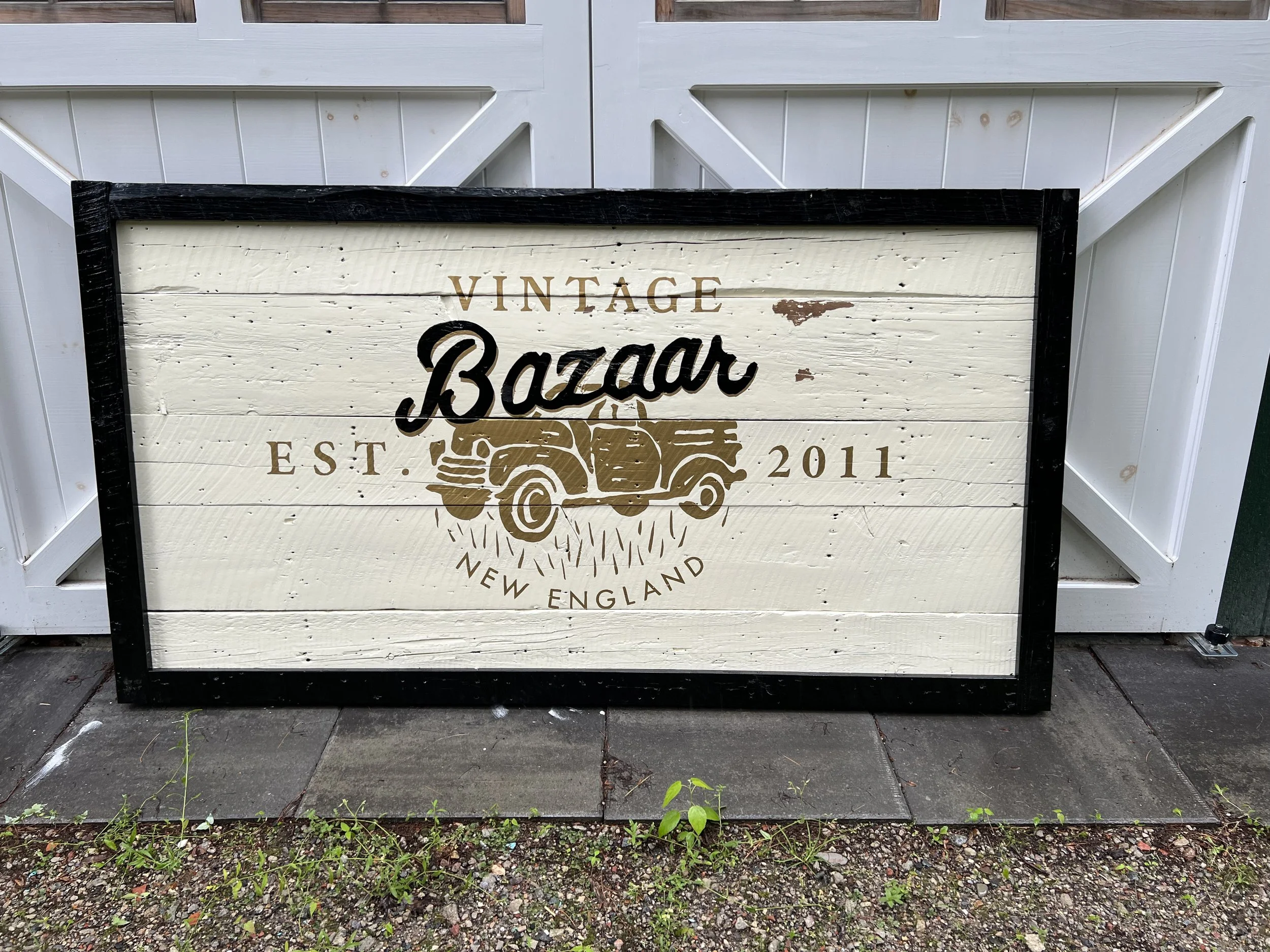 Rustic framed wooden sign reading “Vintage Bazaar, Est. 2011, New England” with a vintage truck graphic.