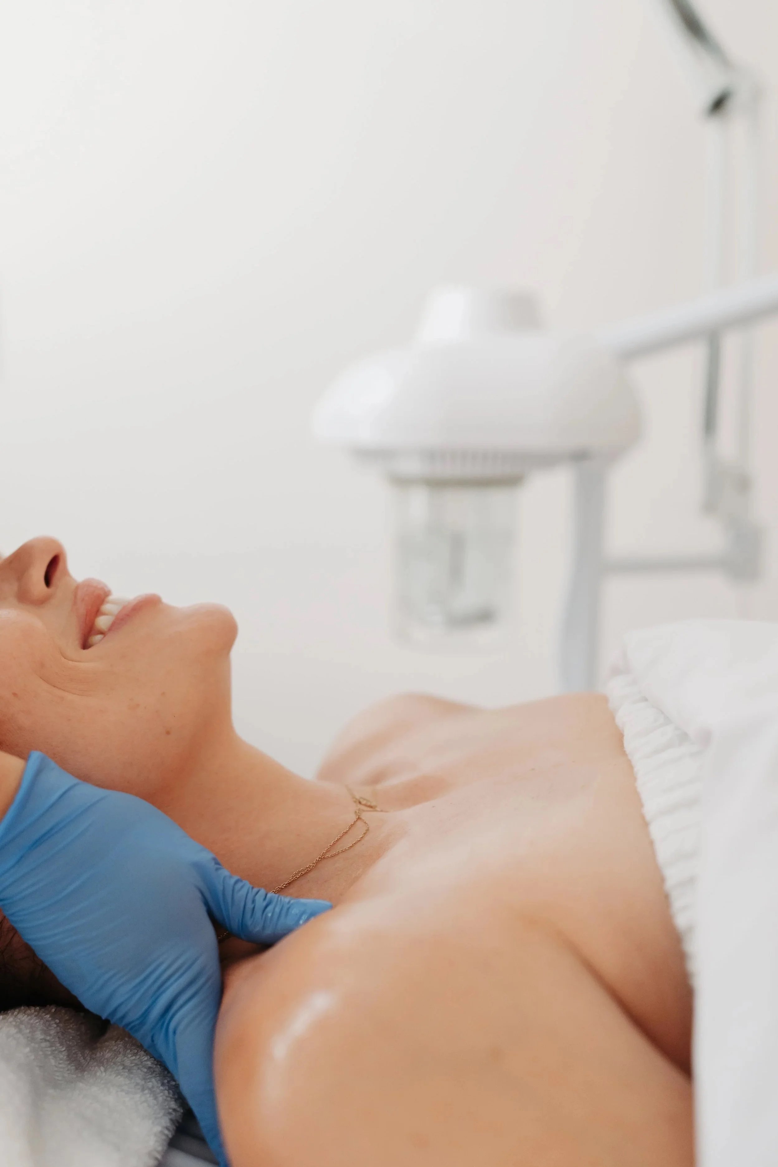 Woman lying on her back with eyes closed getting a facial, in a medical spa at BLUR Aesthetics in Madison/Middleton, WI.