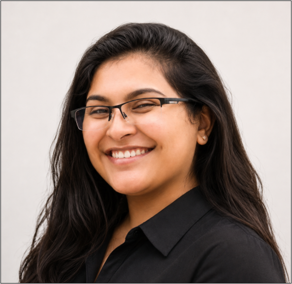A woman with long dark hair, wearing glasses and a black shirt, smiling at the camera.