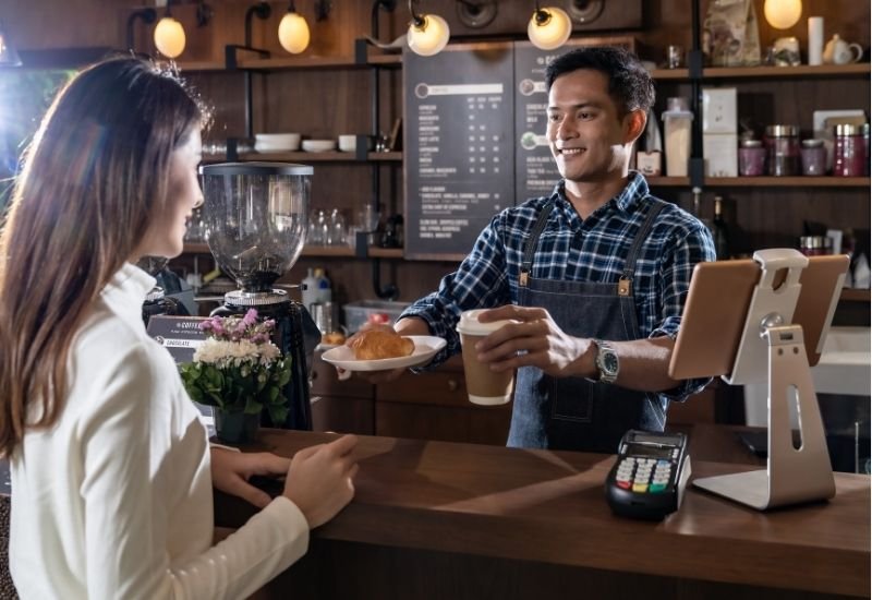 Local café employee serving a customer