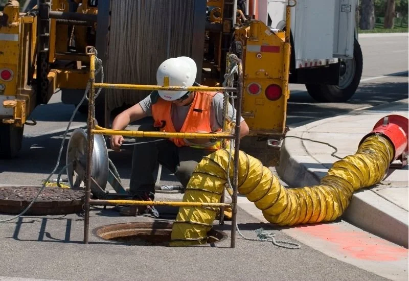 Utility worker accessing underground utility infrastructure