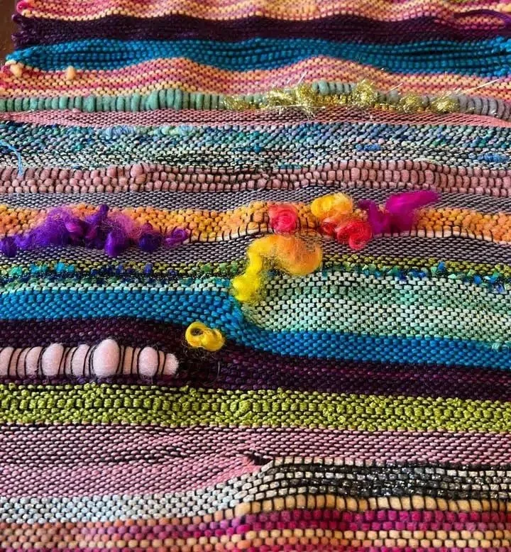 Close-up of a colorful woven textile with various patterns and textures.