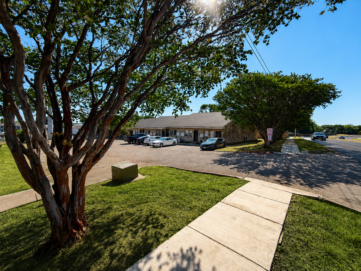 Welcoming exterior view of Park Springs Lofts with mature trees, convenient parking, and easy access from the main road.