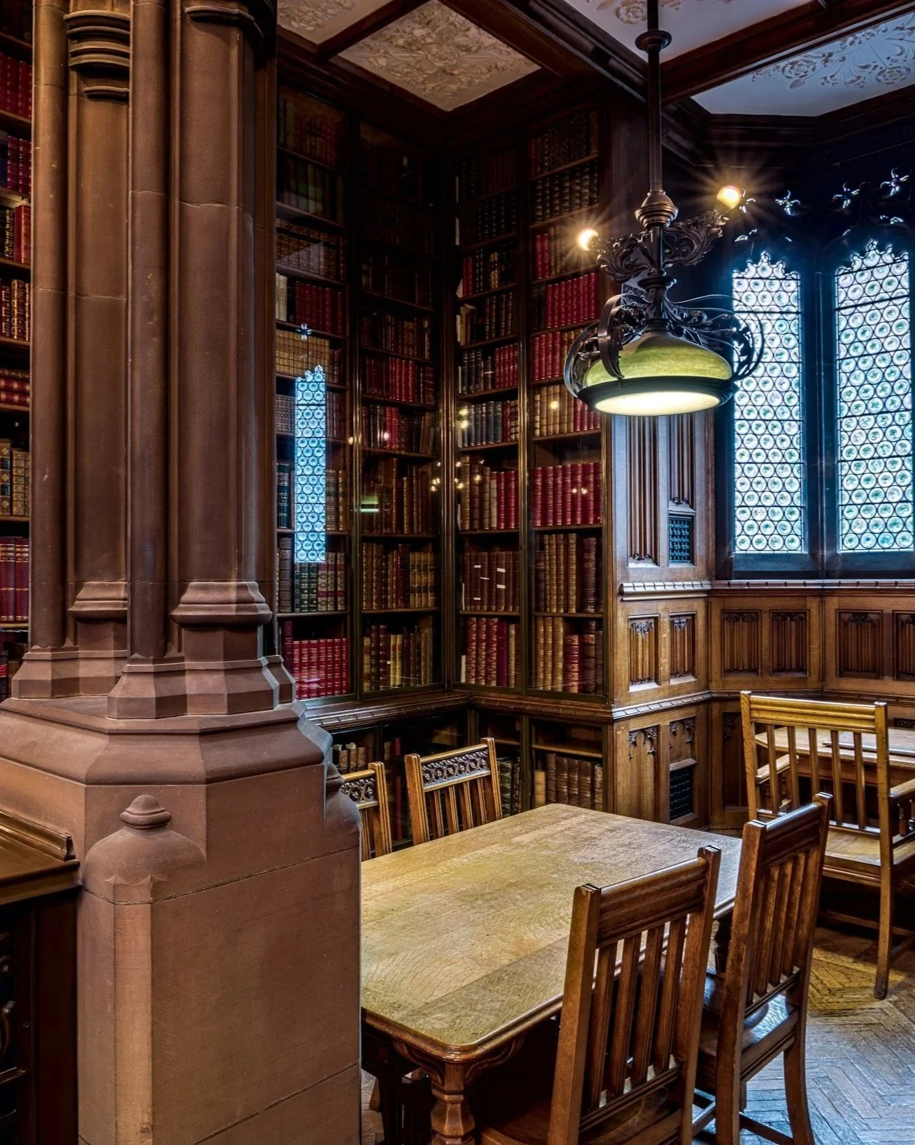 Traditional library with bookshelves, wooden tables, and study space.