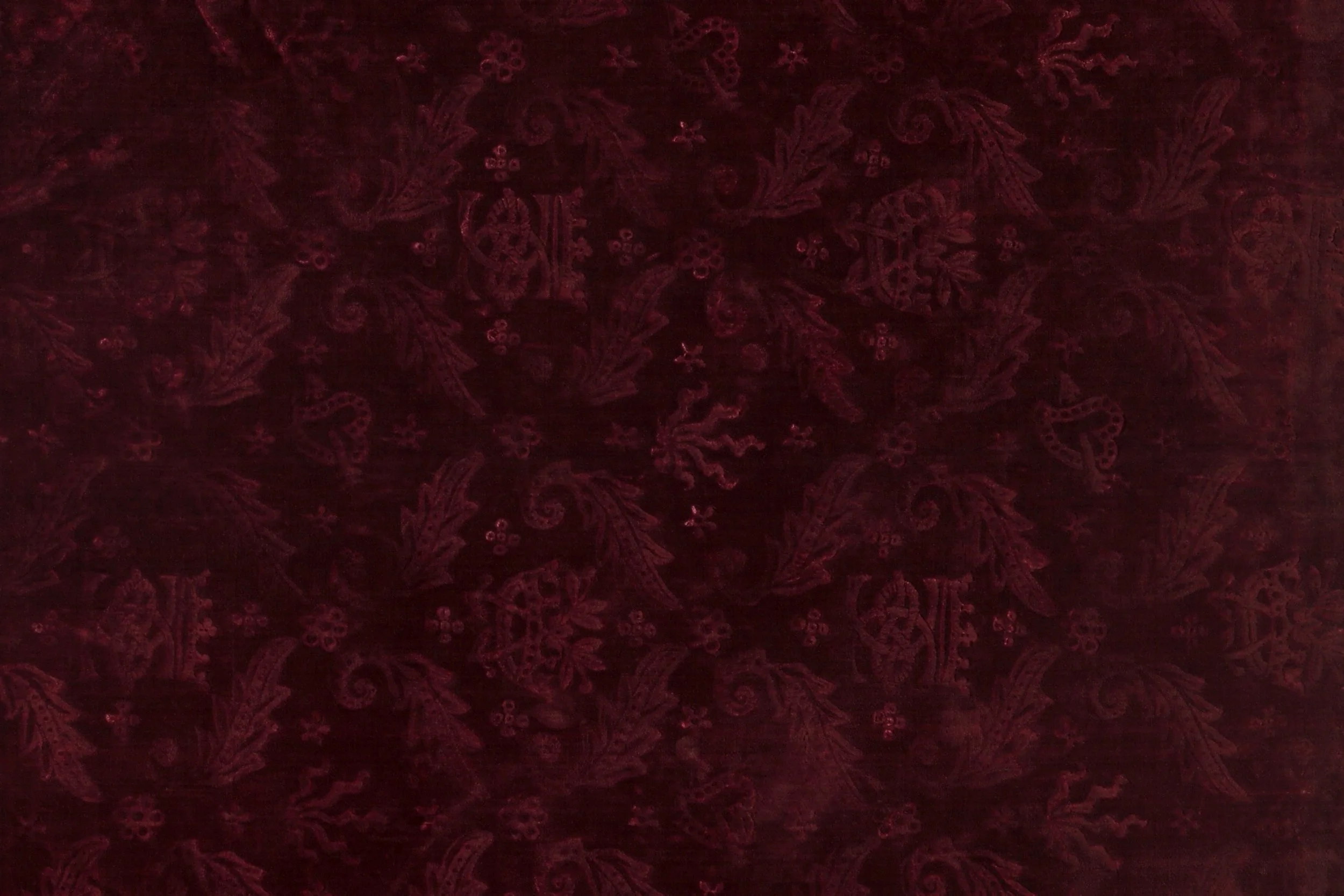 Dark red fabric with intricate floral and paisley pattern.