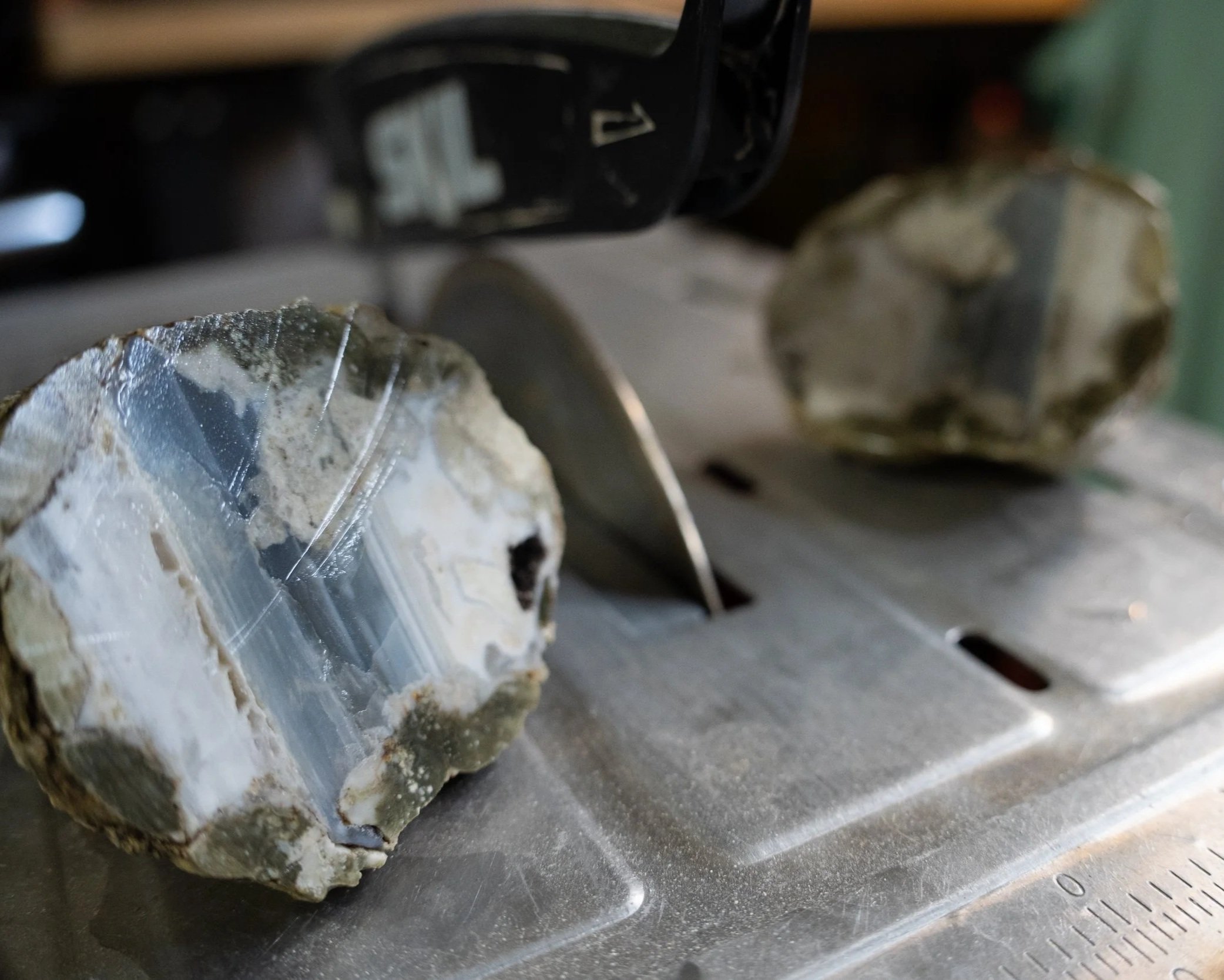 Close-up of a drill cutting through a piece of rock with sparks flying off.