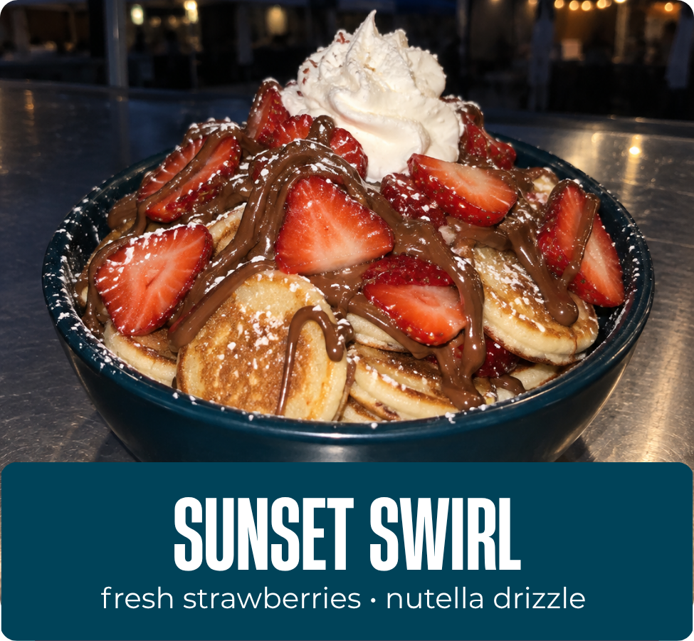 Sunset Swirl mini pancakes with strawberries, whipped cream, powdered sugar and Nutella drizzle.