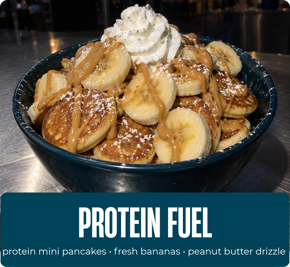 Protein Fuel mini pancakes with bananas, whipped cream, powdered sugar and peanut butter drizzle.