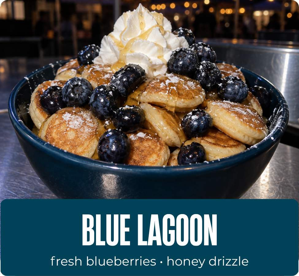 Blue Lagoon mini pancakes with blueberries, whipped cream, powdered sugar and honey drizzle.