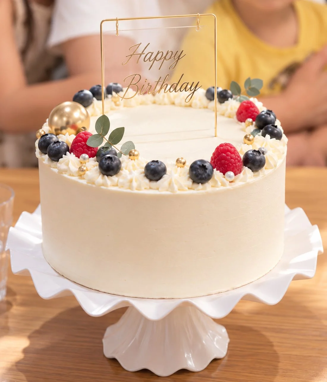 Light and fluffy taro cream cake topped with fresh blueberries and raspberries, finished with delicate cream piping and elegant gold accents.