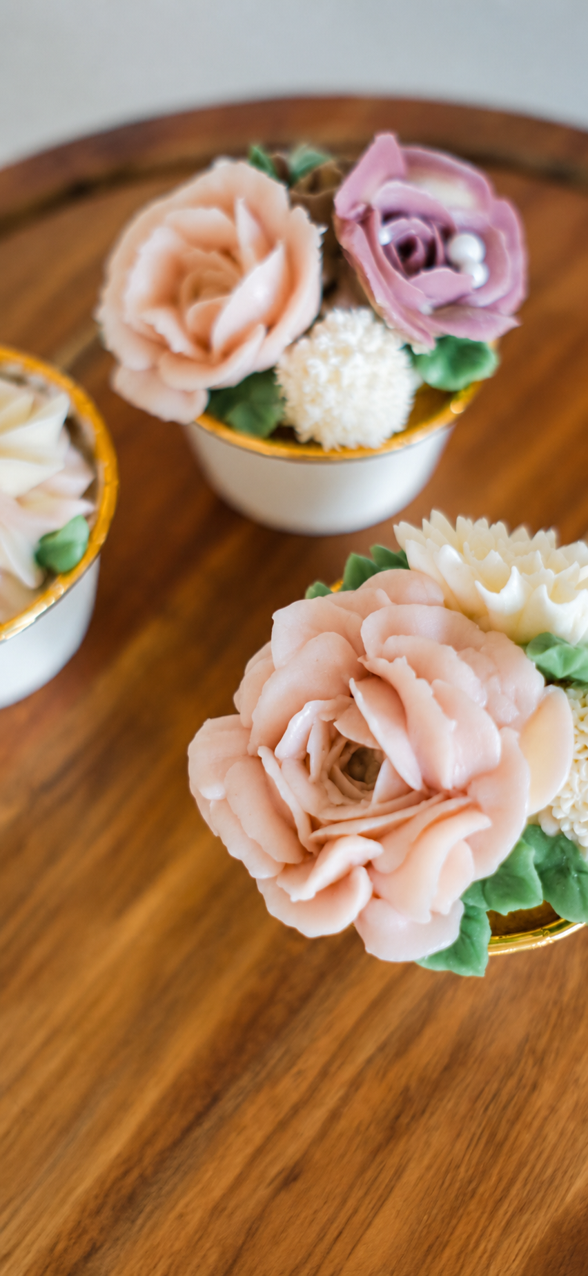 Elegant hand-piped buttercream floral cupcakes featuring delicate roses and blossoms in soft pastel colors, handcrafted by J. Atelier Cake in Utah.
