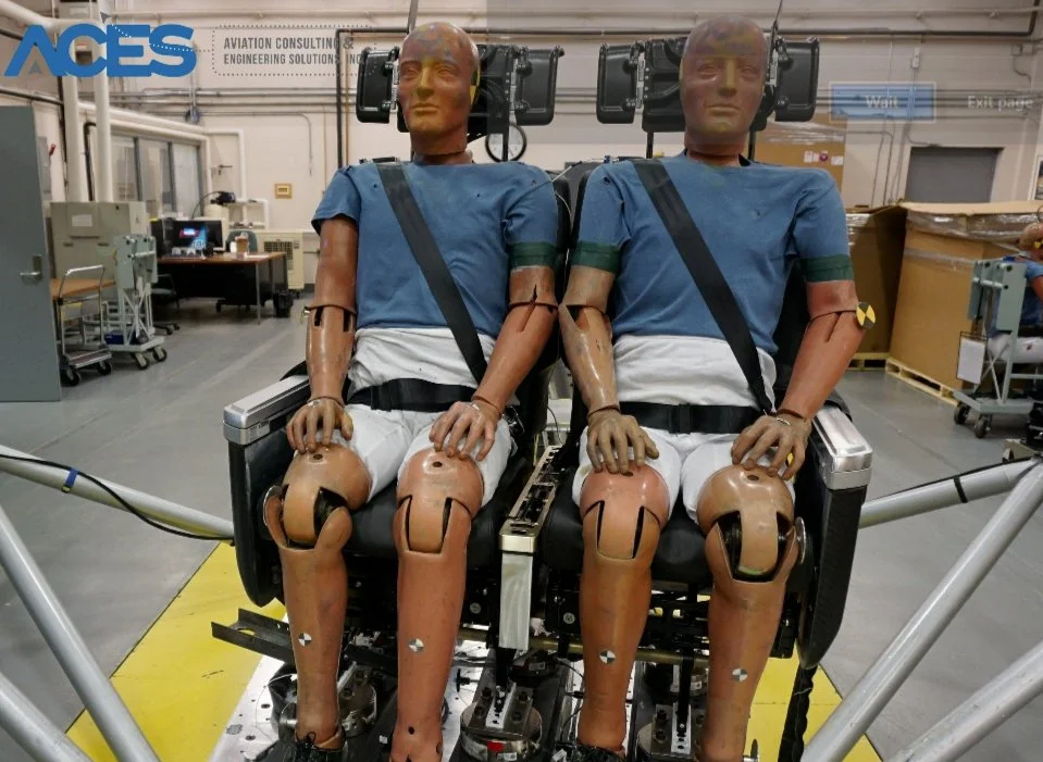 Two crash-test dummies secured in aircraft seats for dynamic sled testing