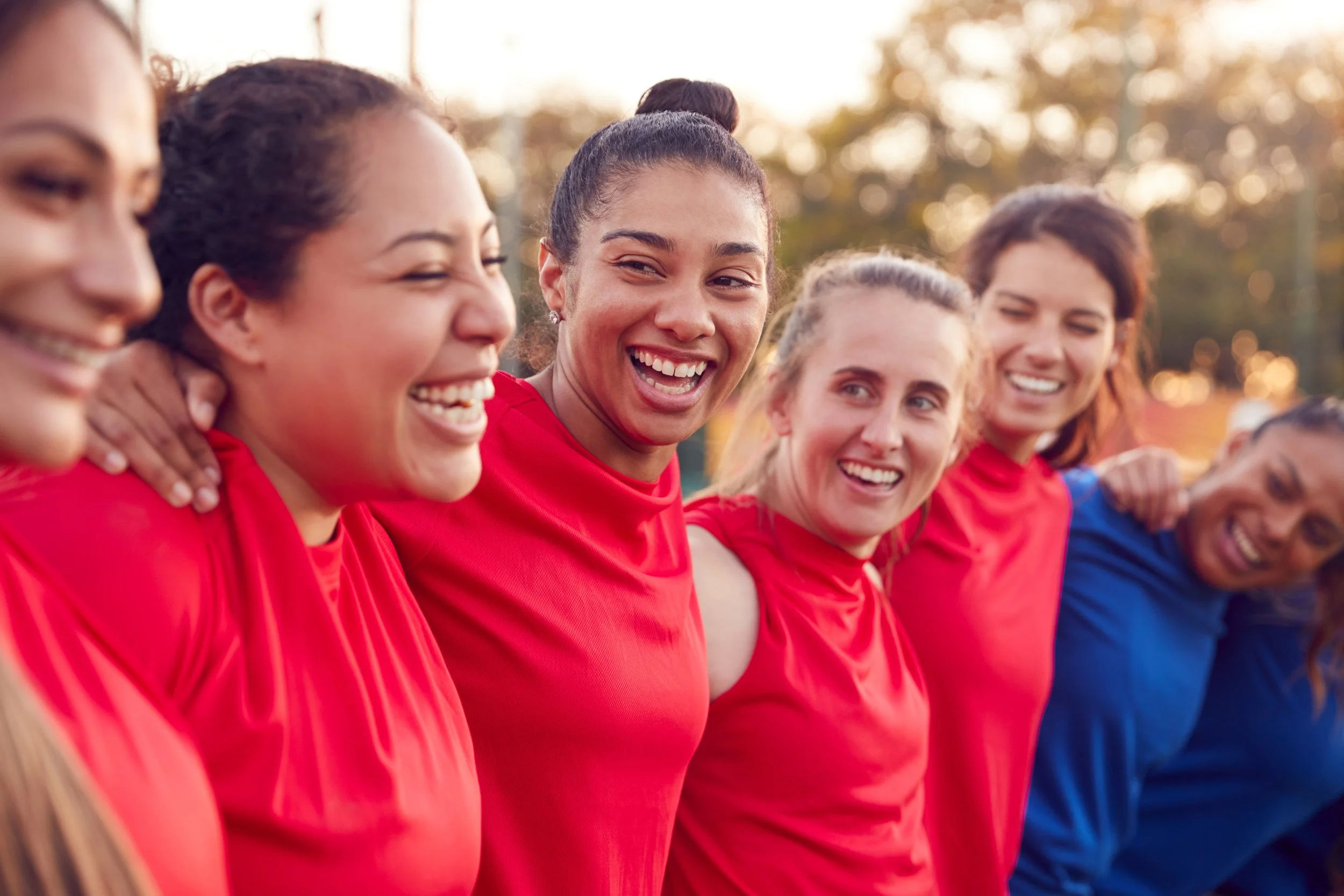 Women's sports team standing together, representing teamwork, belonging and the athlete community.