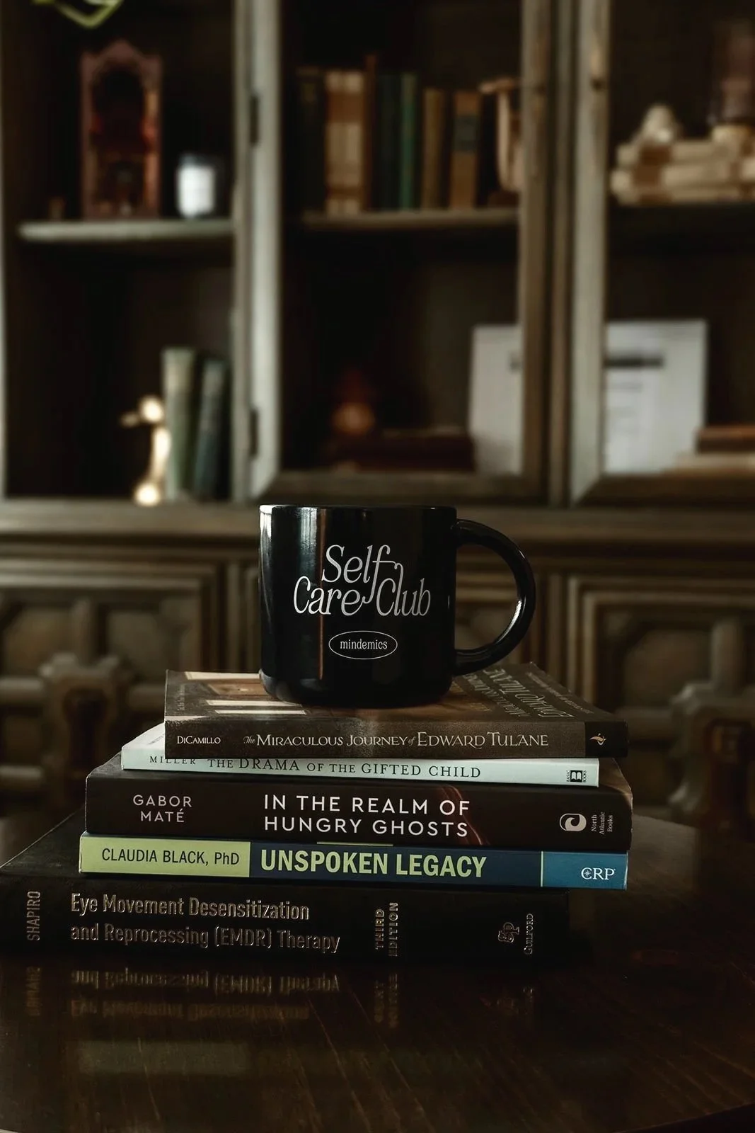 Self Care Club mug on stack of therapy books, EMDR and trauma therapy office Scottsdale Arizona