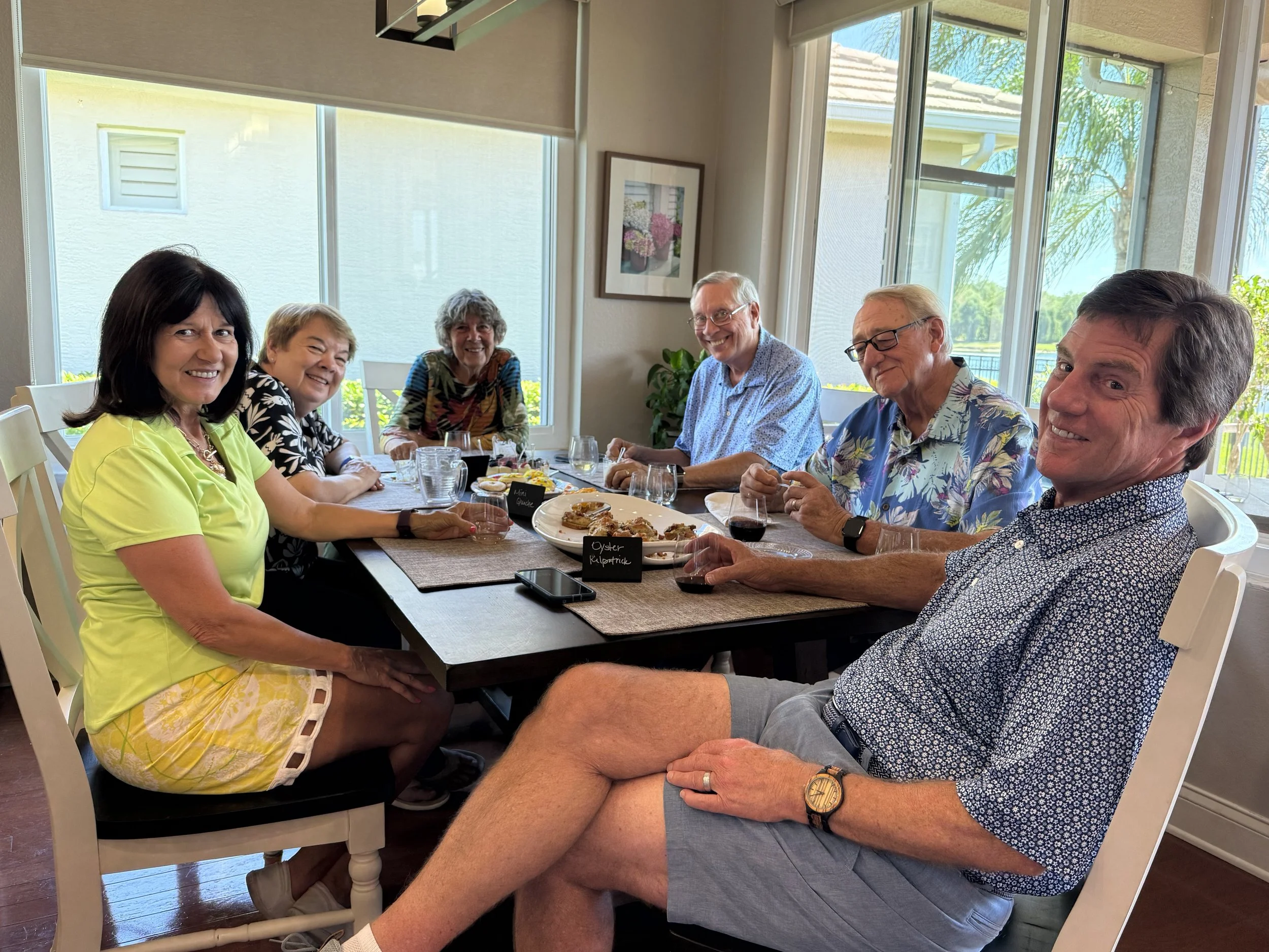 Friends gathered around a table sharing food, wine, and conversation.