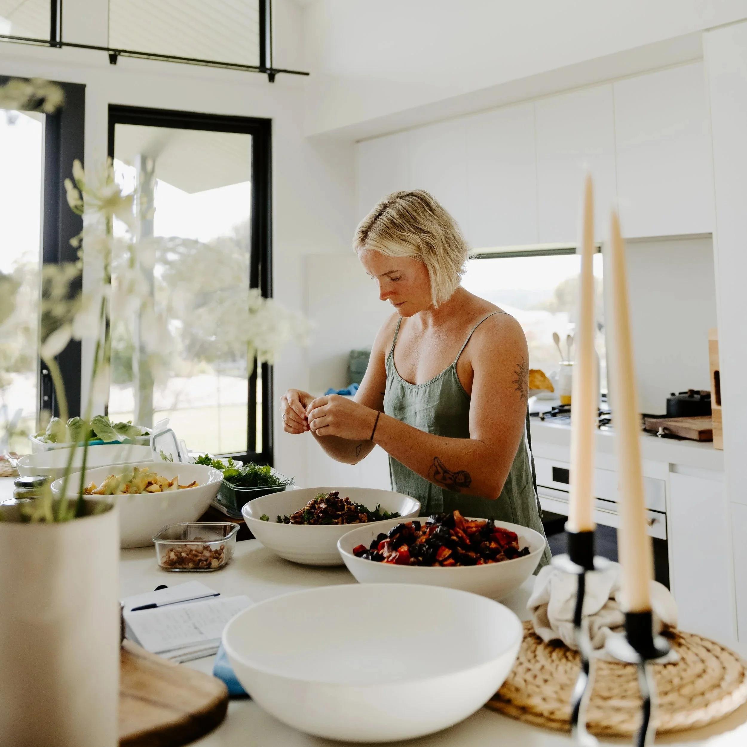 woman making fresh whole food in her kitchen as a caterer for events and retreats