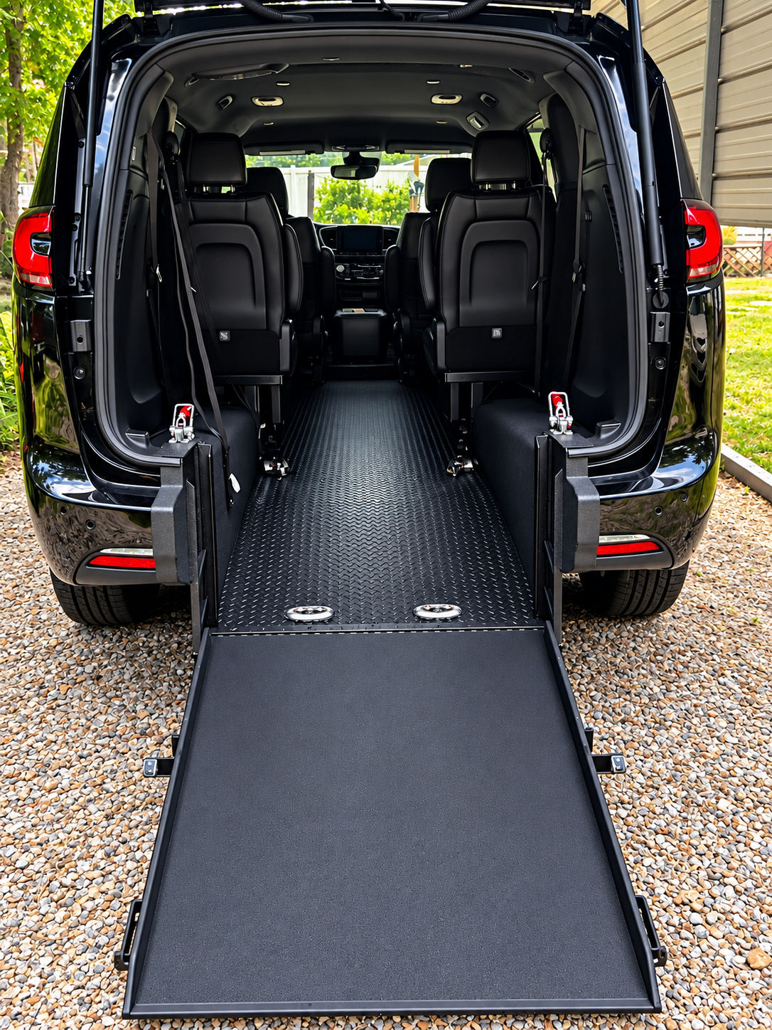 Interior of a wheelchair accessible van with a lowered ramp, black seats, and space for mobility devices.