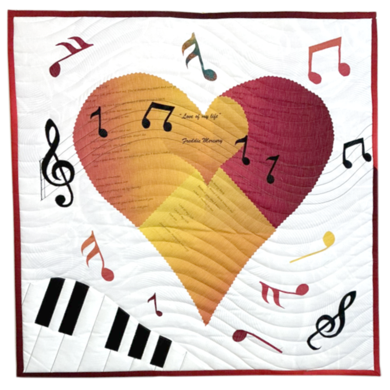 Colorful quilt featuring a large heart with musical notes and a keyboard, with the quote "Love of my life" and the name Gabbie Moreno.