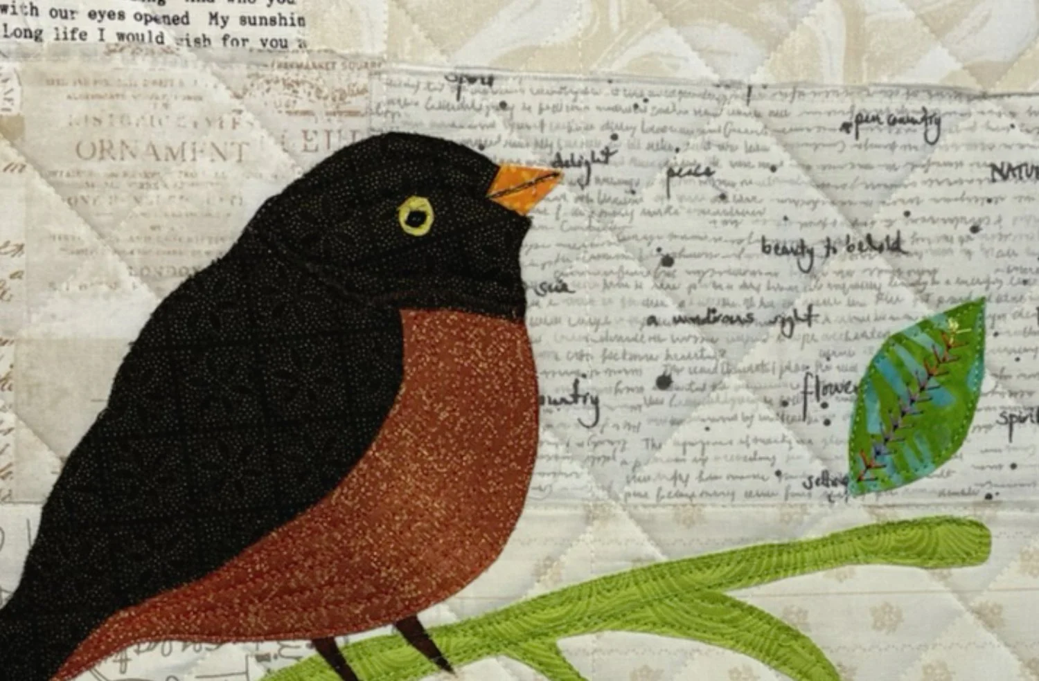A quilted fabric art piece featuring a colorful bird perched on a green branch, with a background of handwritten text and decorative elements.