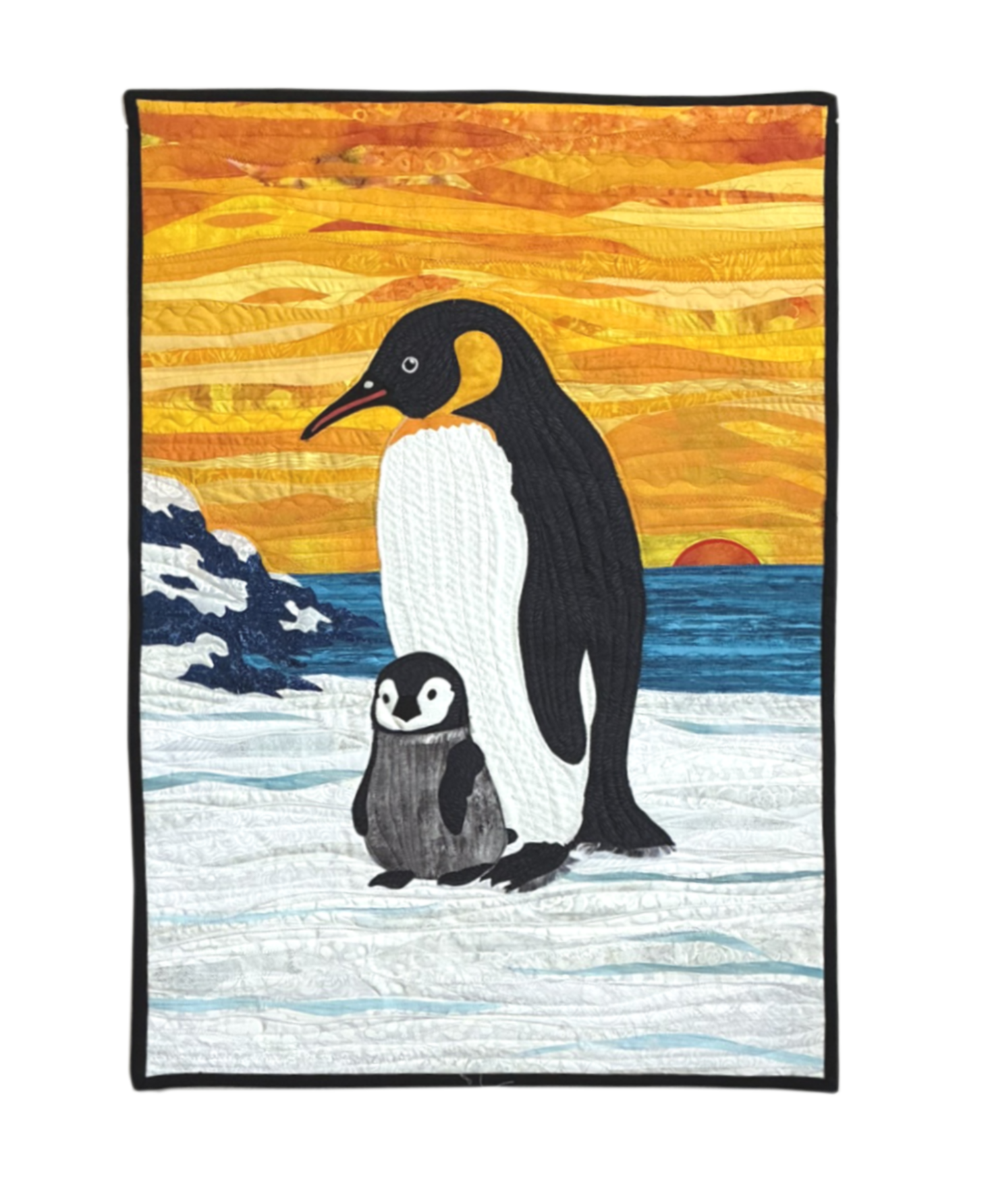 A quilt depicting a scene with penguins, ocean waves, and a sunset with a vibrant sky of orange, yellow, and red hues.