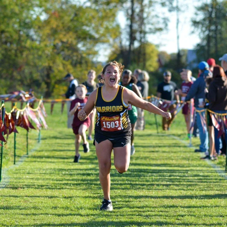 A young female athlete in a black and yellow 