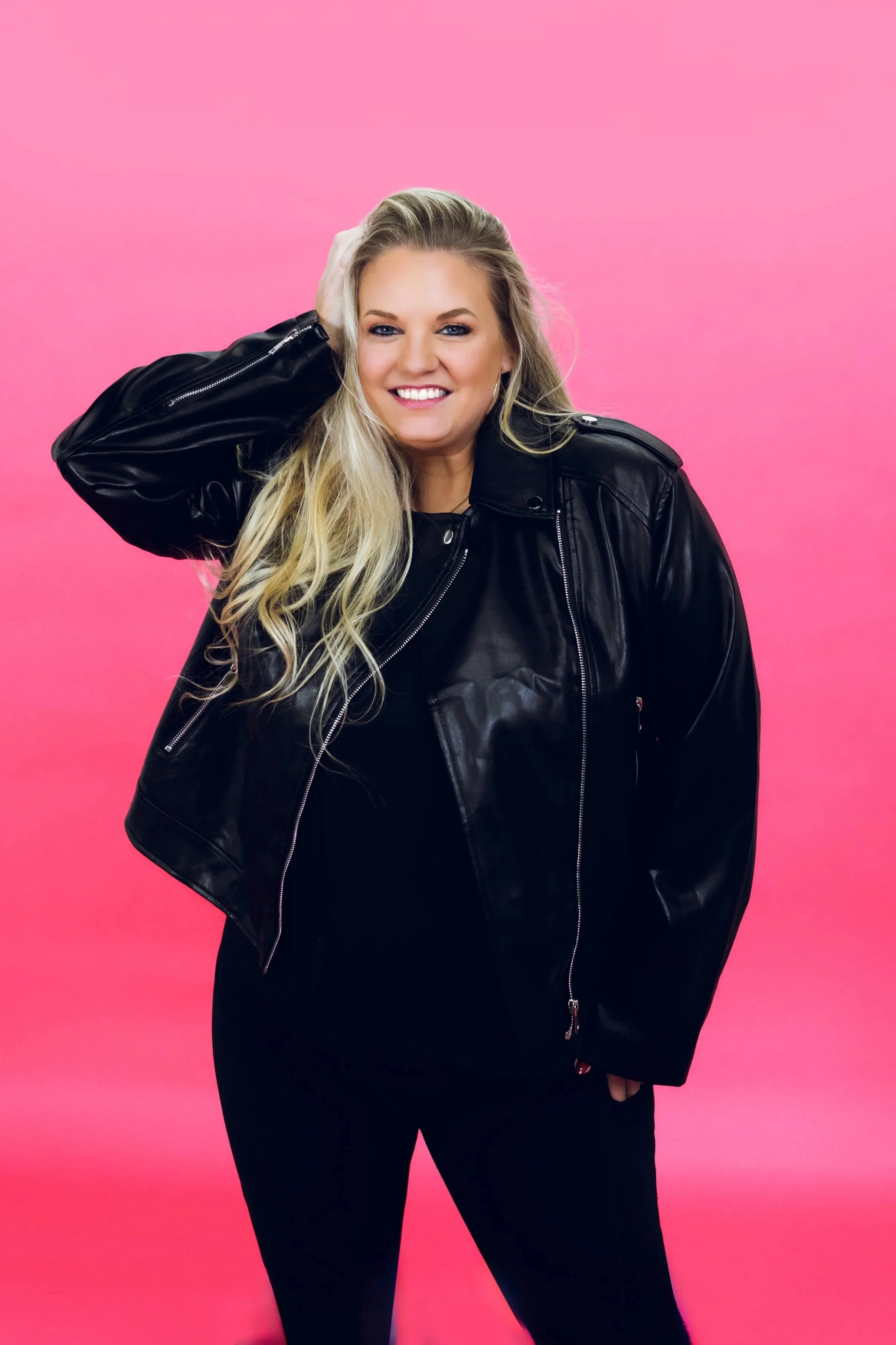 Noelle Messa, co-owner of Sequel Dance Complex in Collierville, TN smiling and standing with a pink background.