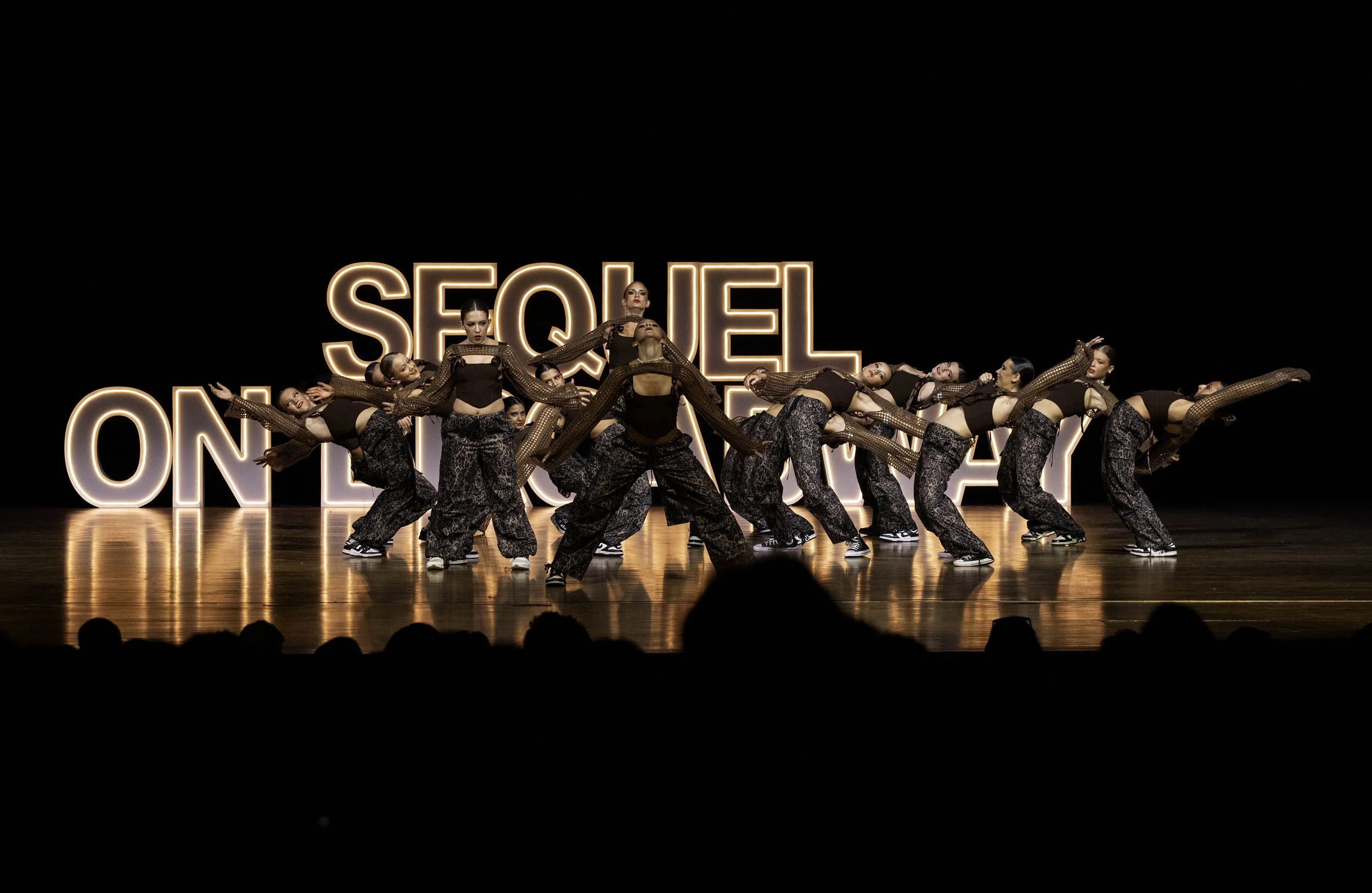 Costumed dancers performing contemporary choreography at Sequel Dance Complex recital