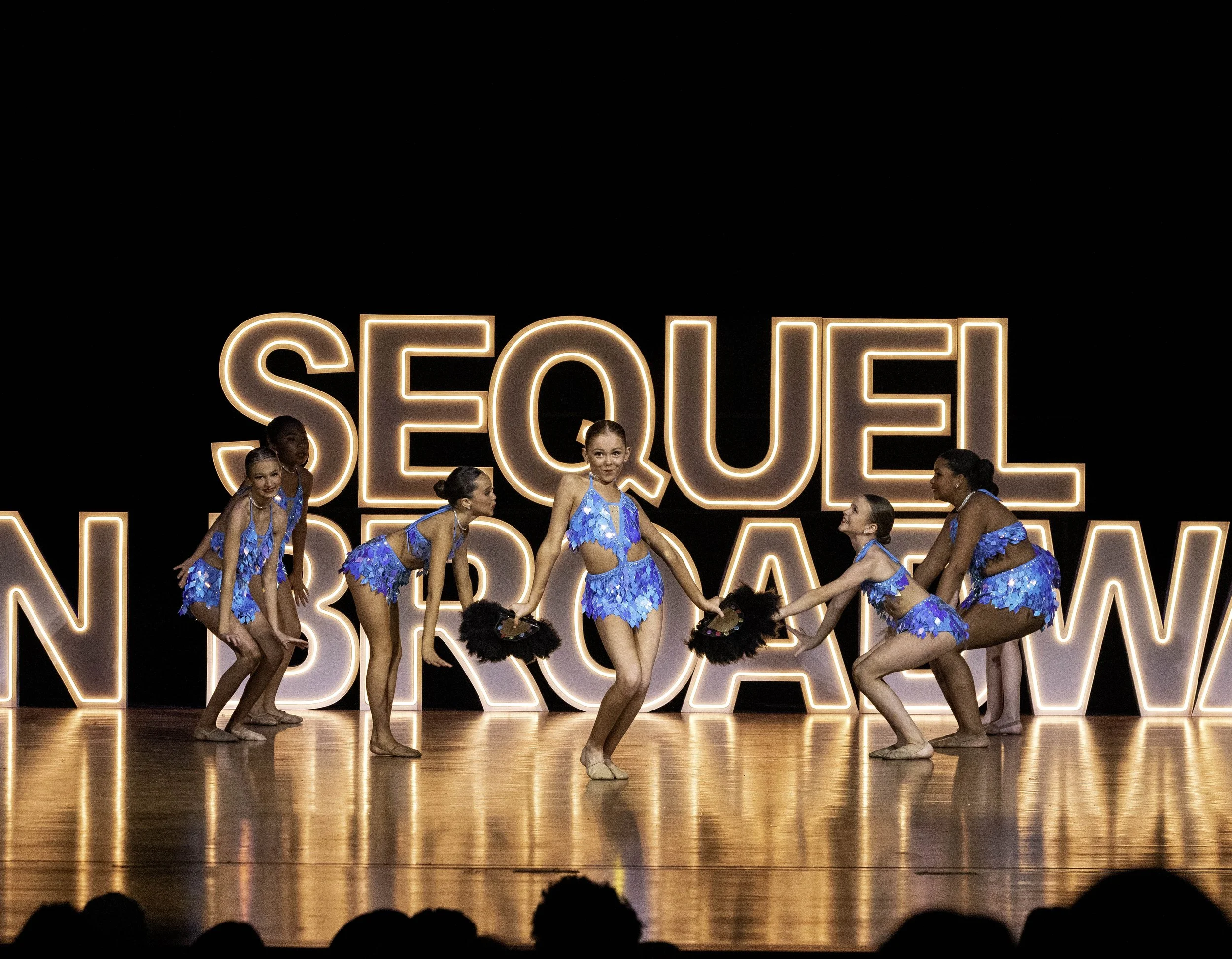 Costumed dancers performing contemporary choreography at Sequel Dance Complex recital