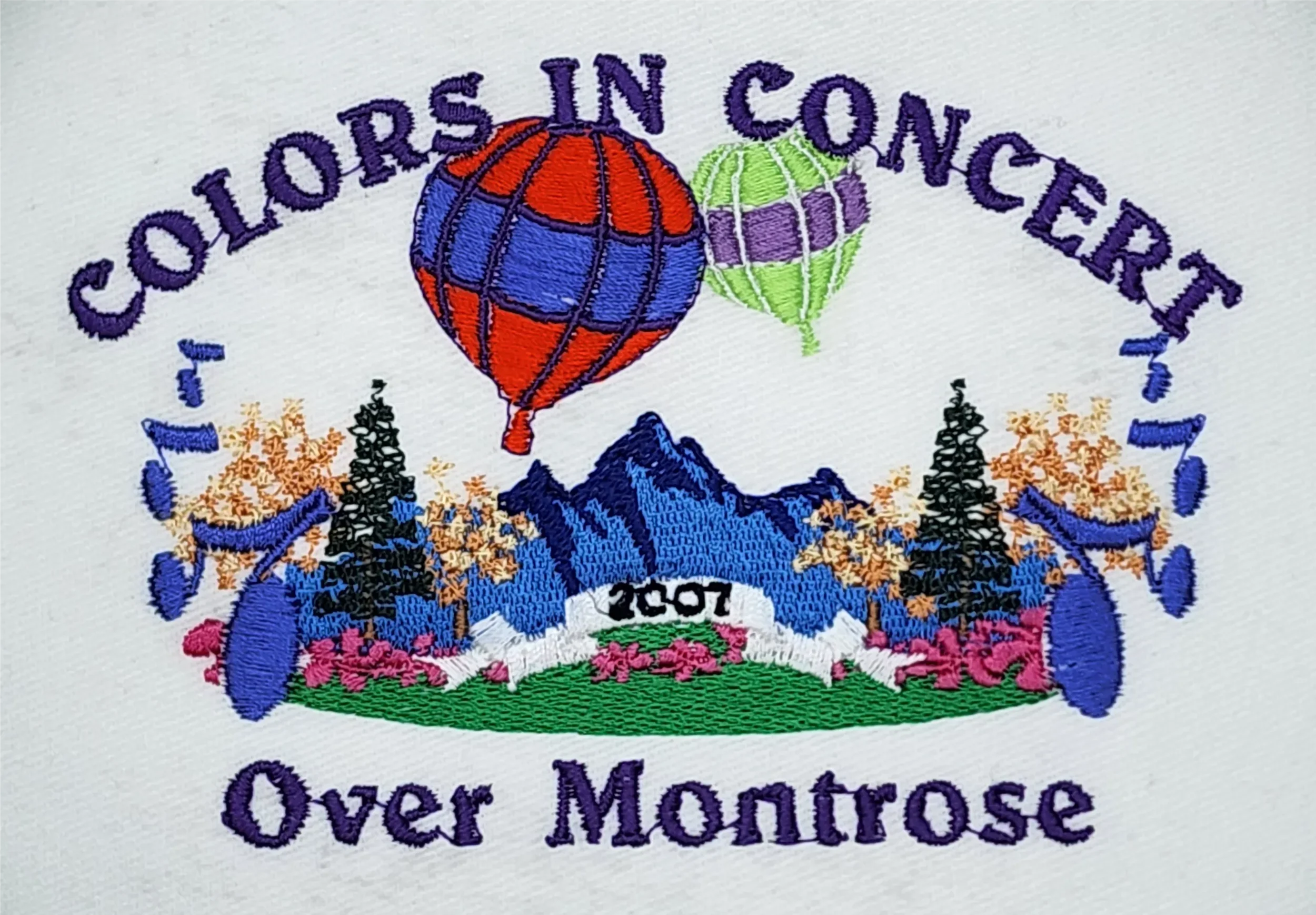 Detailed stitch work view of hand digitized Colors in Concert embroidered logo on polos.