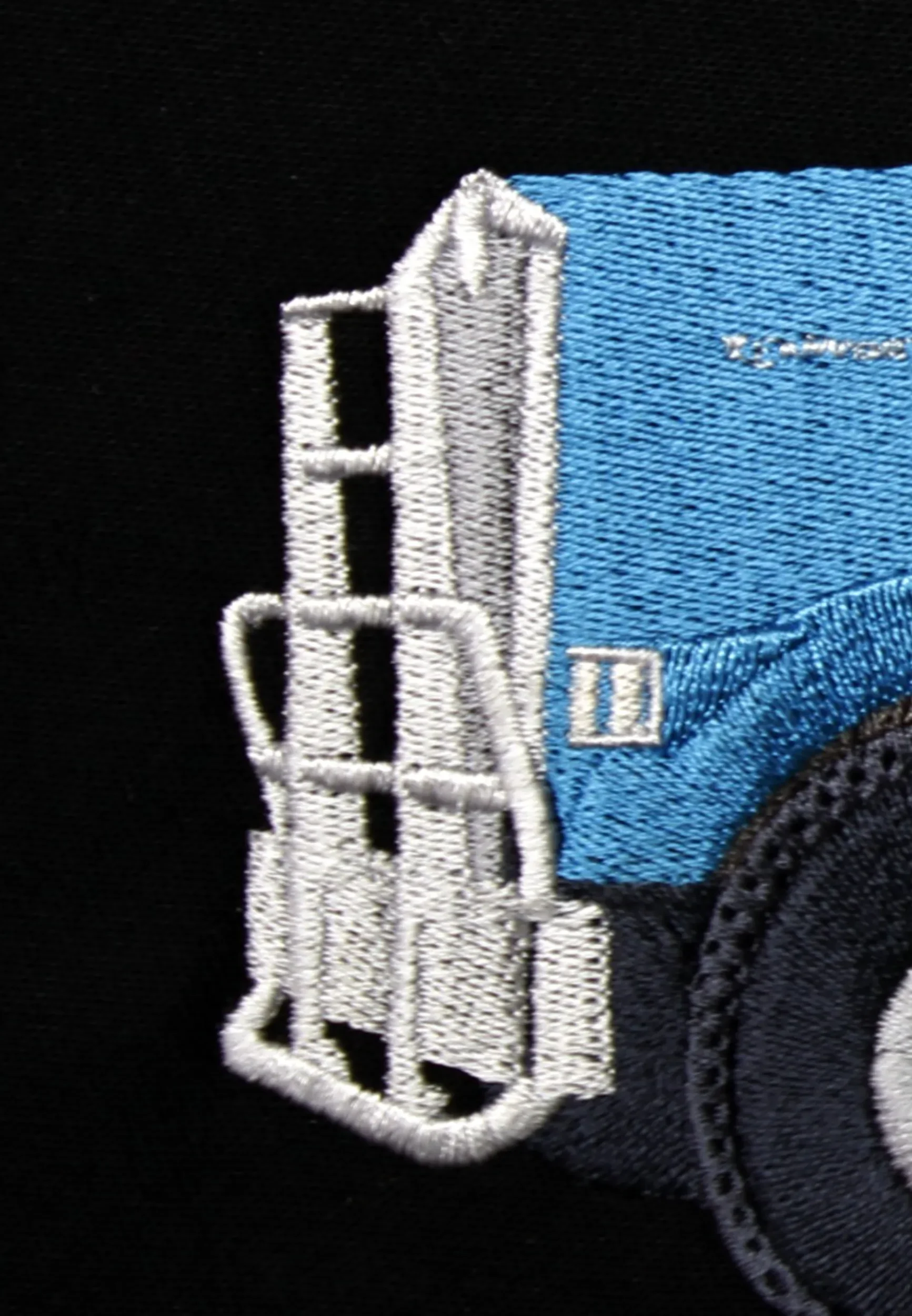 Front grill stitch detail of hand digitized blue semi-truck custom embroidery.