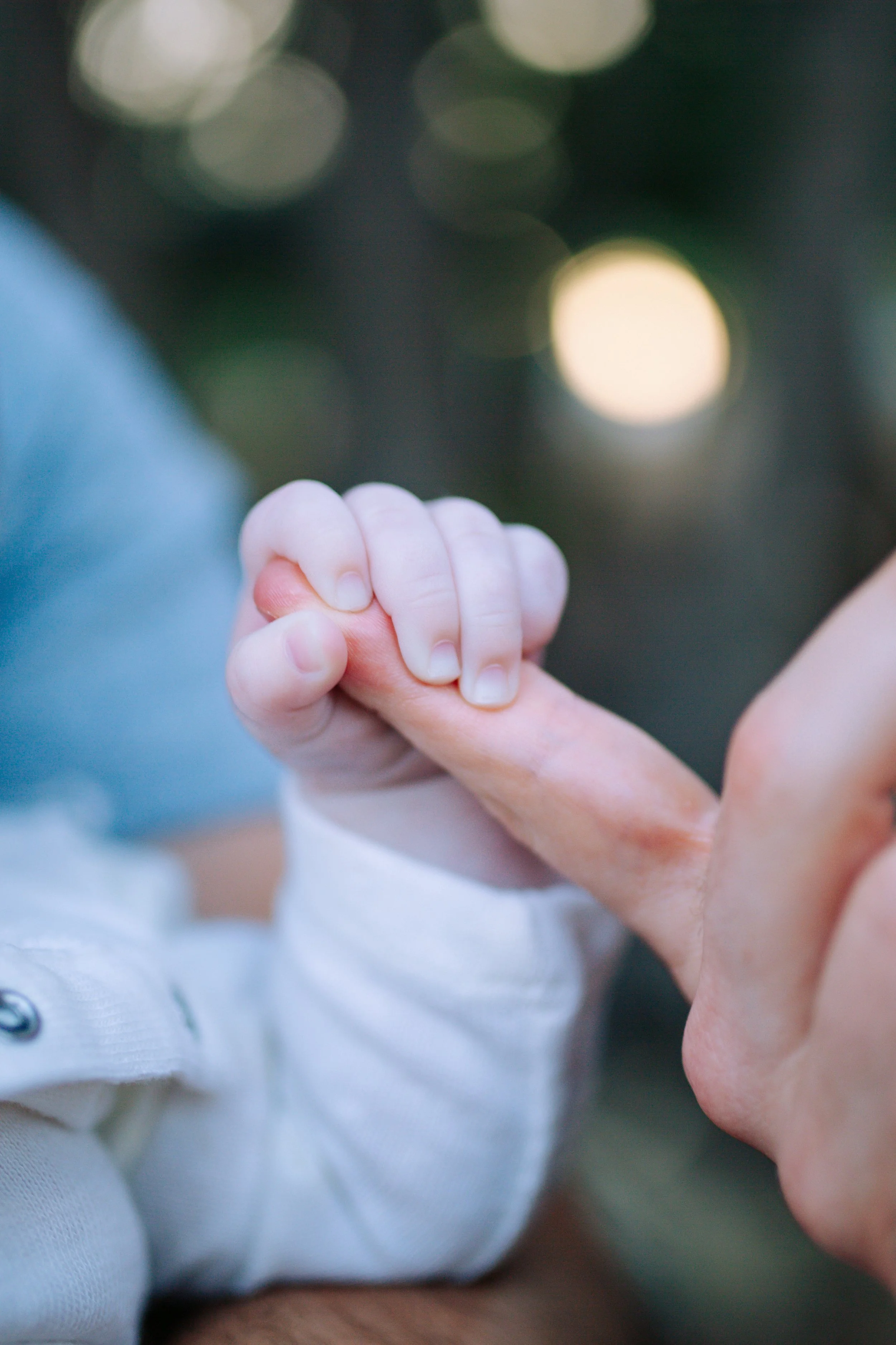 Baby holding a parent's finger, San Diego newborn and family photographer