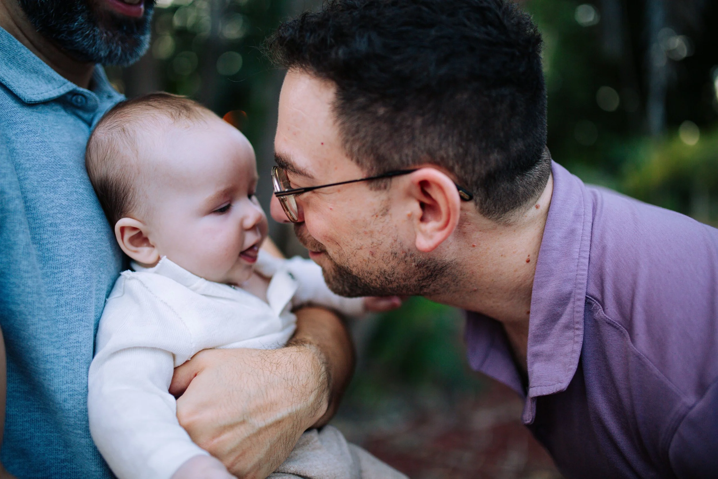 New parents holding their baby outdoors, San Diego family photography