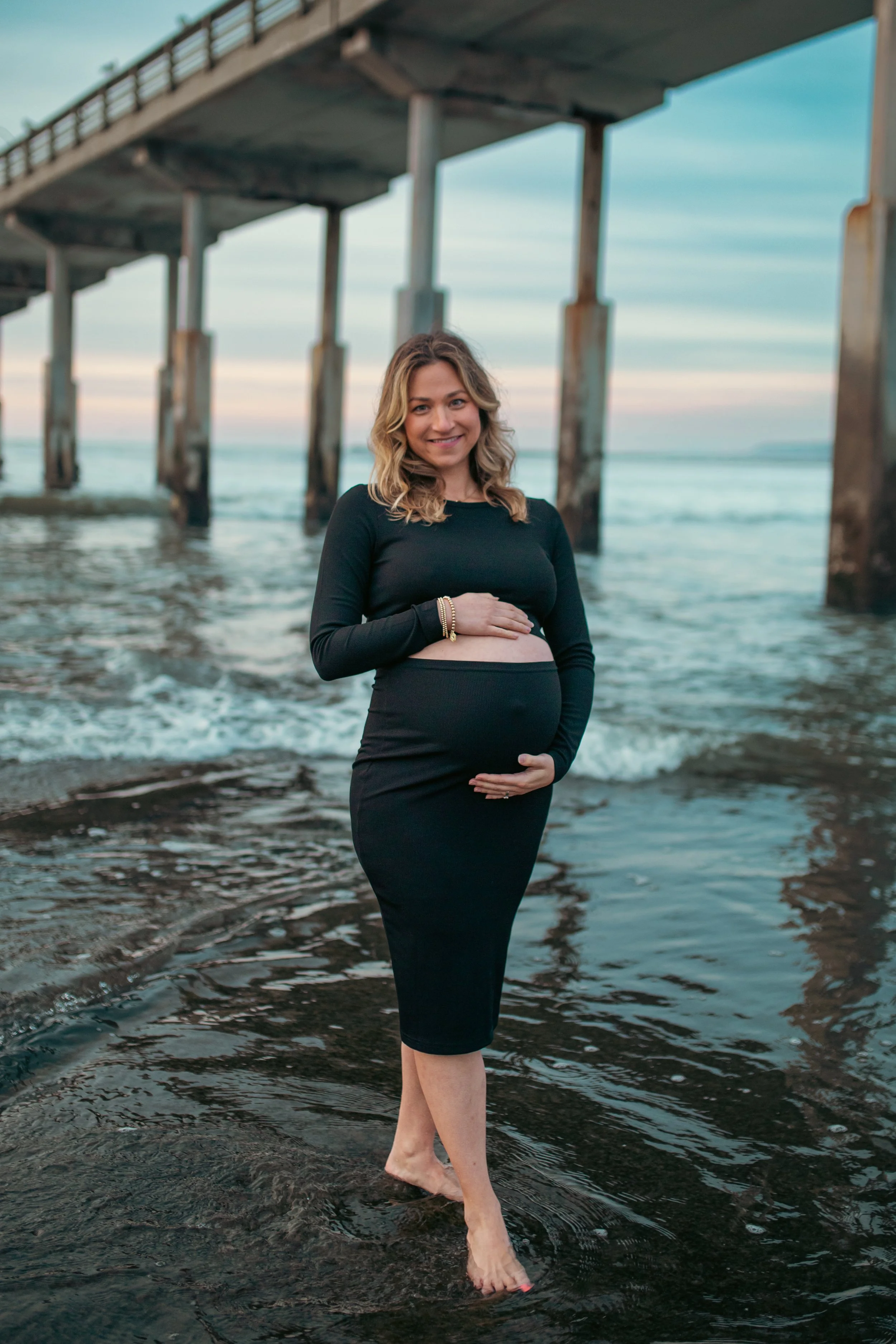 Expecting couple embracing on the rocks at Sunset Cliffs, San Diego maternity photographer
