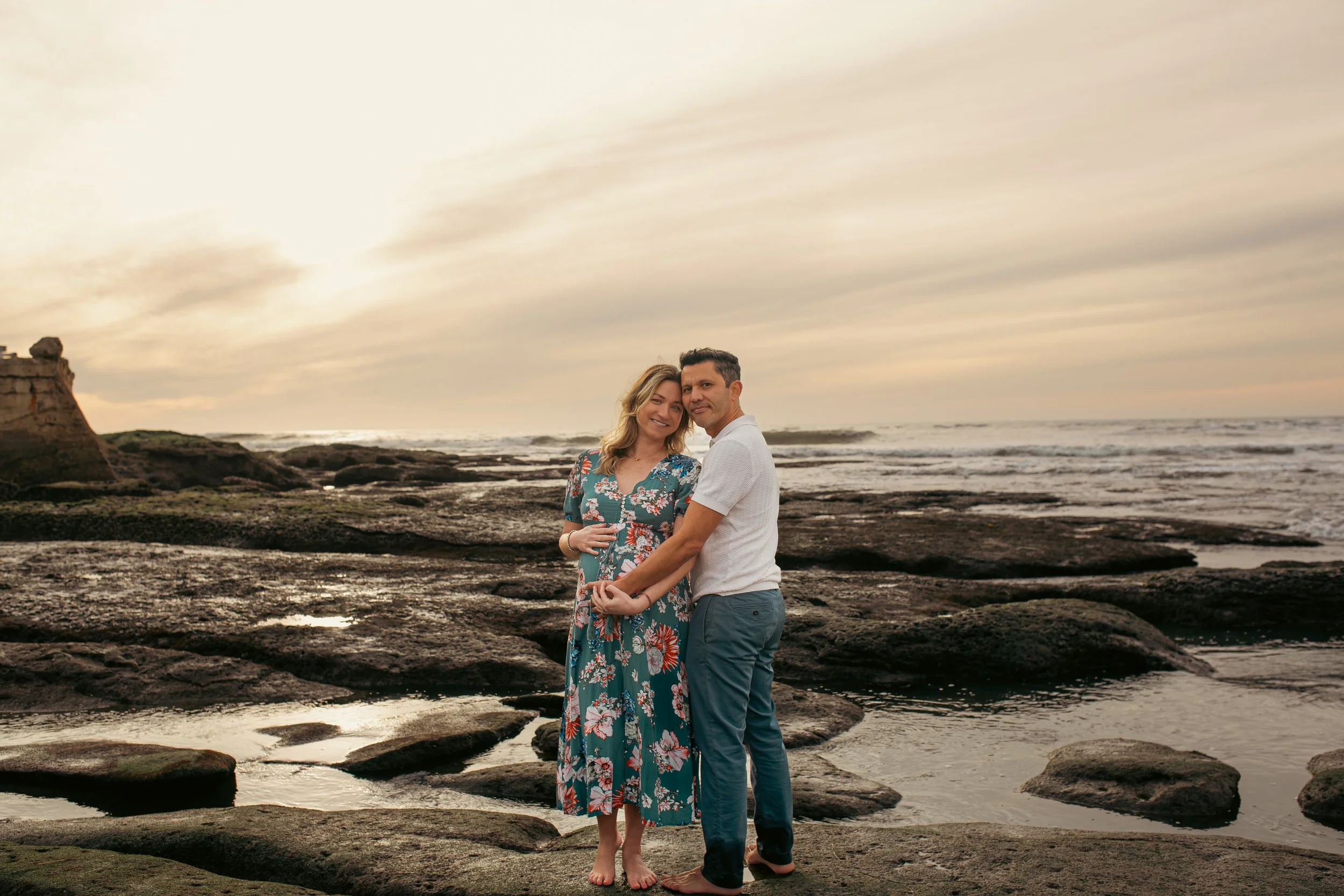 Expecting couple embracing on the rocks at Sunset Cliffs, San Diego maternity photographer