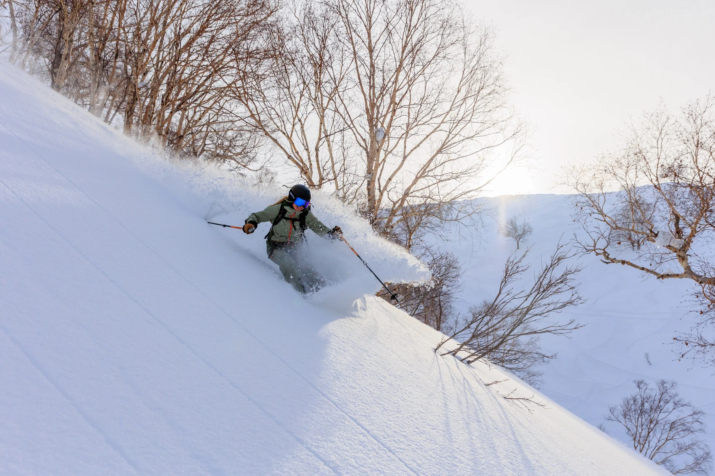 Skier descending through deep powder snow in Niseko, Hokkaido