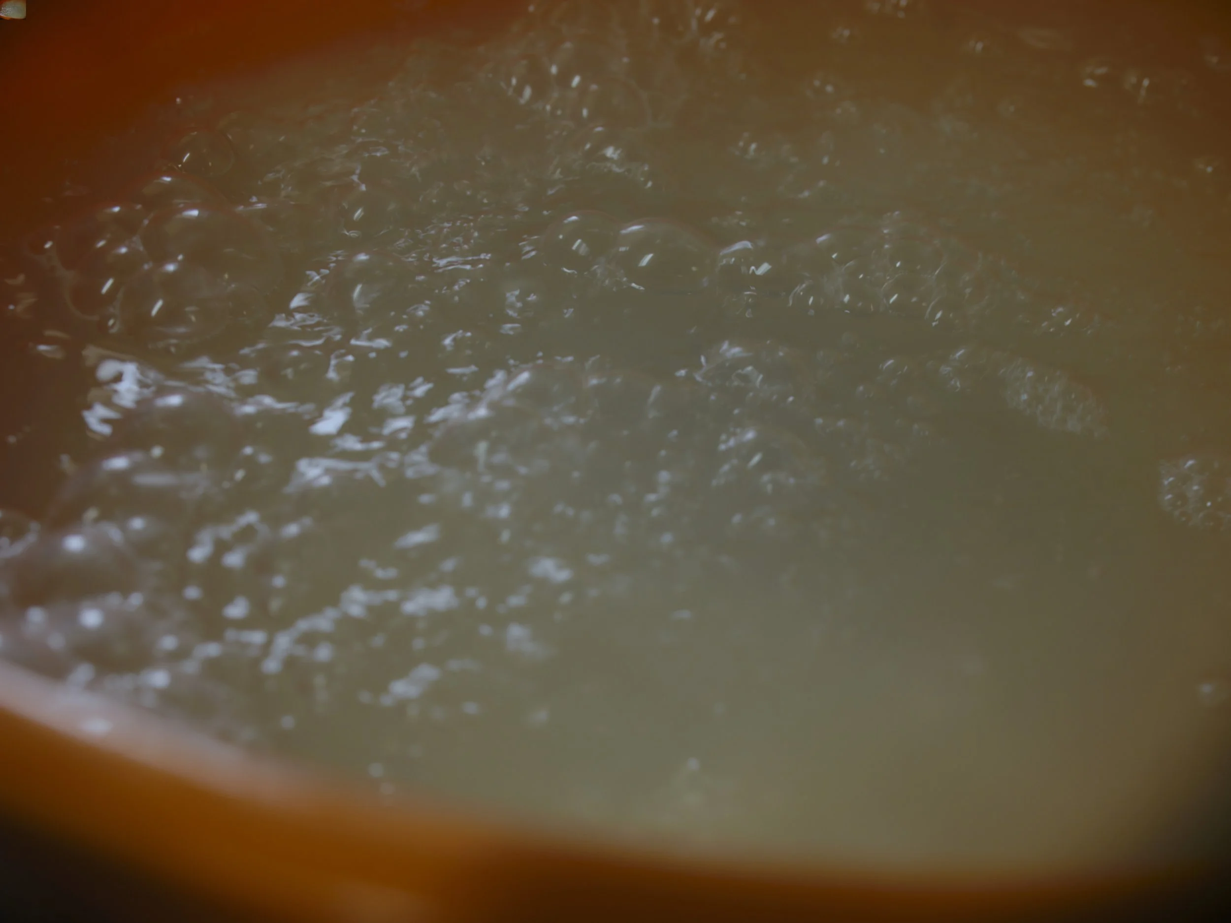 Close-up of bubbles in a liquid, possibly foam or a carbonated beverage inside a container.