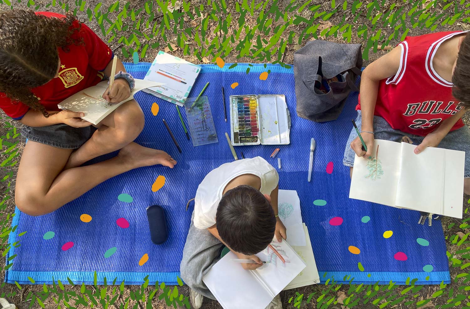 Trois enfants dessinant et coloriant sur une toile bleue à l'extérieur, avec des fournitures artistiques autour et un décor de feuilles vertes et confettis colorés
